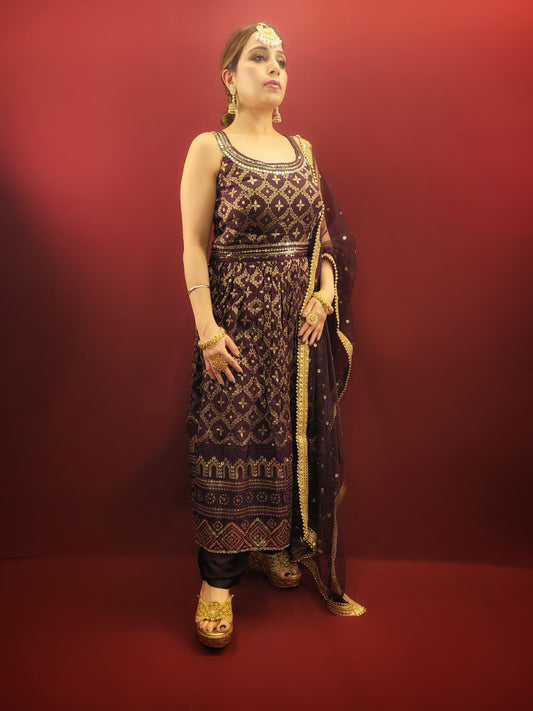 Embrace sophistication with a touch of sparkle in this captivating wine-colored Nayra pant set. Crafted from luxurious Banarasi fabric, the kameez drapes beautifully, offering a comfortable and elegant silhouette.