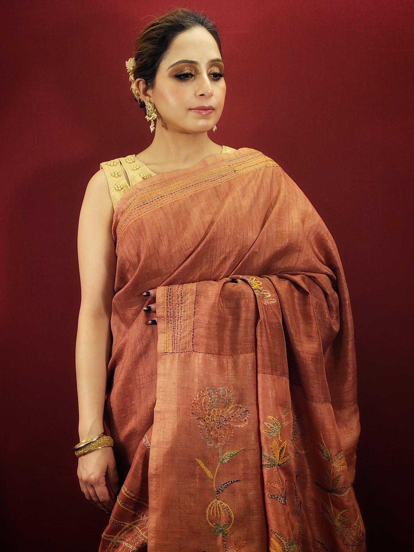 Crafted from pure silk, this saree offers a luxurious feel and a beautiful drape that flatters any figure. The rich, rust color exudes a warm and earthy elegance, perfect for making a sophisticated statement. The captivating brush print design adds a touch of modern artistry, while the delicate katha stitch highlights lend a timeless charm.