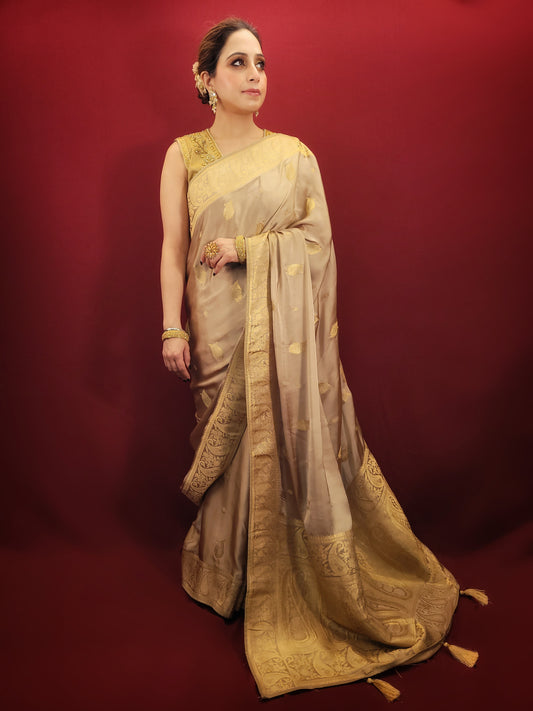 A beautiful saree in beige golden hue, crafted from satin silk with banarsi woven pattern, radiates timeless elegance, perfect for any party wear ocassion.