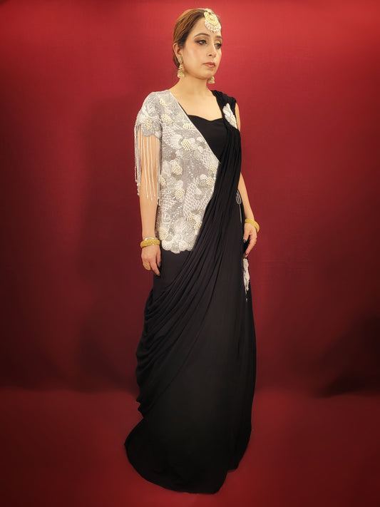 Embrace the allure of mystery with this sophisticated Black Georgette Drape Saree set. Crafted from luxuriously flowing georgette, this ready-to-wear saree drapes effortlessly, creating a silhouette that exudes timeless elegance. With dazzling designer shrug.