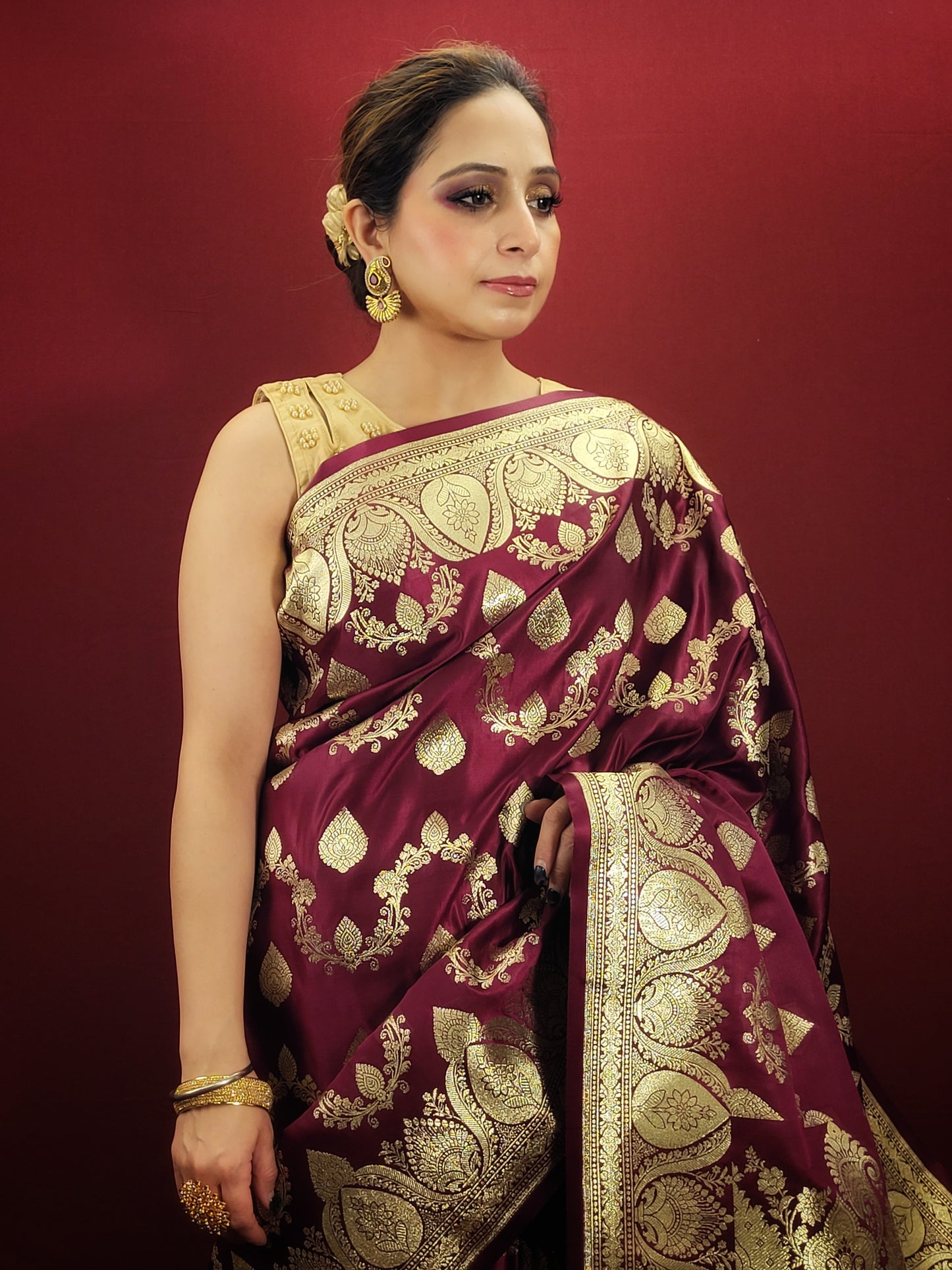 Embrace the grandeur of Indian weddings with a maroon Banarsi saree, adorned with zari woven artistry, perfect for party and wedding celebrations.