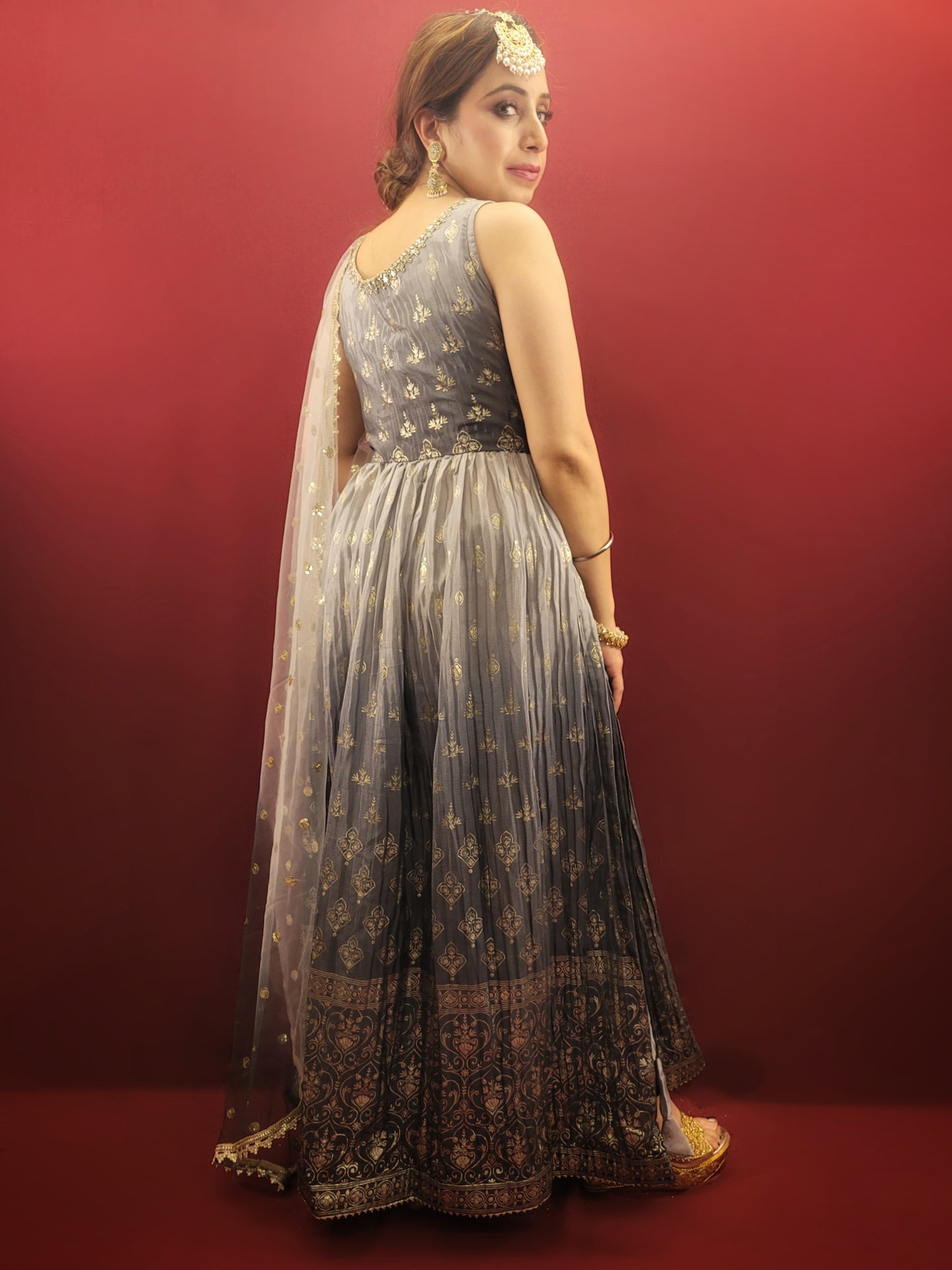 The Nayra suit, with its graceful grey ombre setting and chic Pant Set, is accentuated with traditional block prints and sparkling zarkan, crafted from flowing chinnon, making it a sophisticated ethnic ensemble for women's party wear.