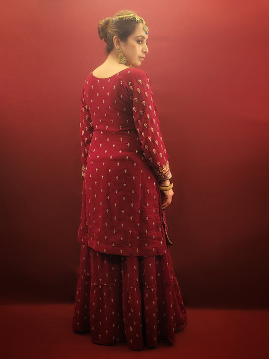 Embrace a vibrant symphony of color and elegance with this Maroon Georgette Gharara Suit. The rich maroon georgette fabric drapes beautifully, creating a flowy silhouette that flatters every figure. The true star of the show, however, is the exquisite multicolor thread work that adorns the kameez and gharara pants.