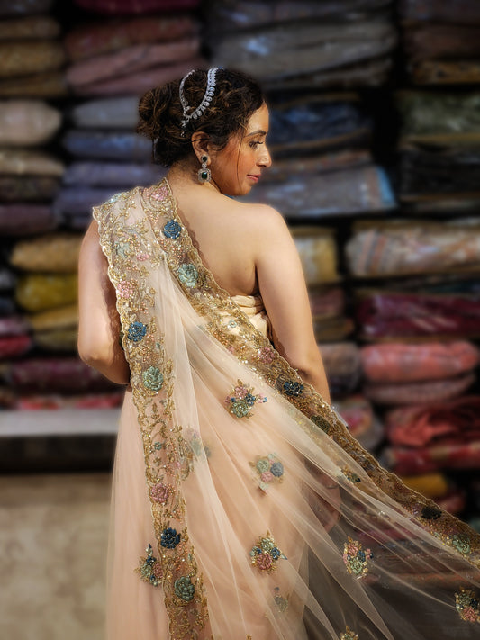 Be the center of attention in this breathtaking light peach net saree, reminiscent of Alia Bhatt's iconic Met Gala look. This captivating piece features exquisite handwork with shimmering resham, cutdana, and sequin embellishments, creating a dazzling display that will leave you feeling like a true star.