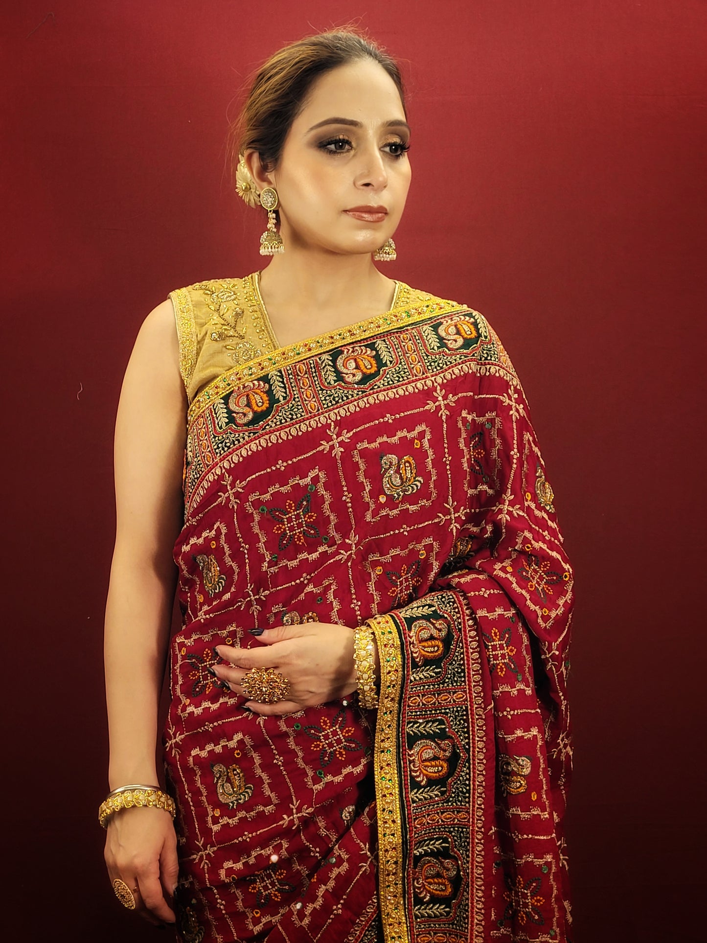 Take a look at this stunning maroon red ethnic saree with a green pallu that's perfect for weddings and bridal wear. The saree is made of gajji silk fabric and features intricate work using cutdana, thread, and zari. It's a beautiful piece that will surely catch everyone's eye.