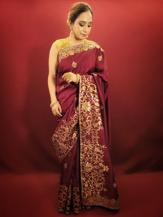 This wine silk saree with intricate gota patti work is perfect for any occasion, be it a party, a festival or a wedding. The rich wine color adds to its elegance and the gota patti work lends it a traditional touch.