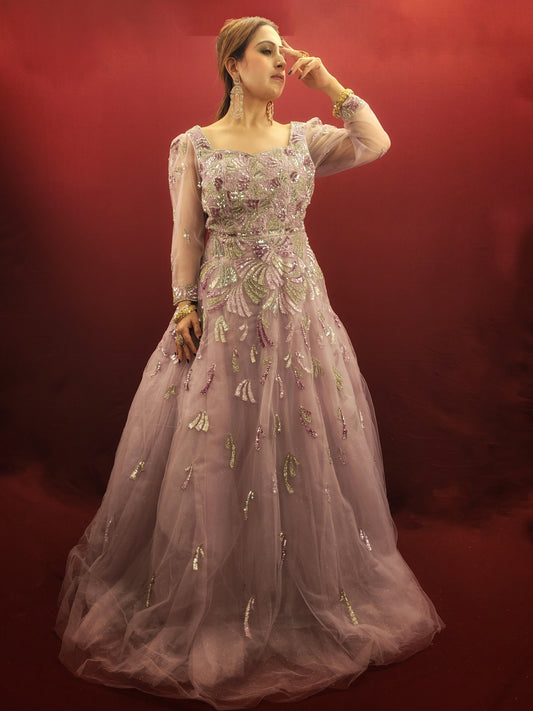 Embrace a vision of soft, romantic grace in this pale mauve net flared gown. This captivating piece transcends occasion, making it perfect for engagements, receptions, or even an arty evening where you want to feel like a whimsical dream.