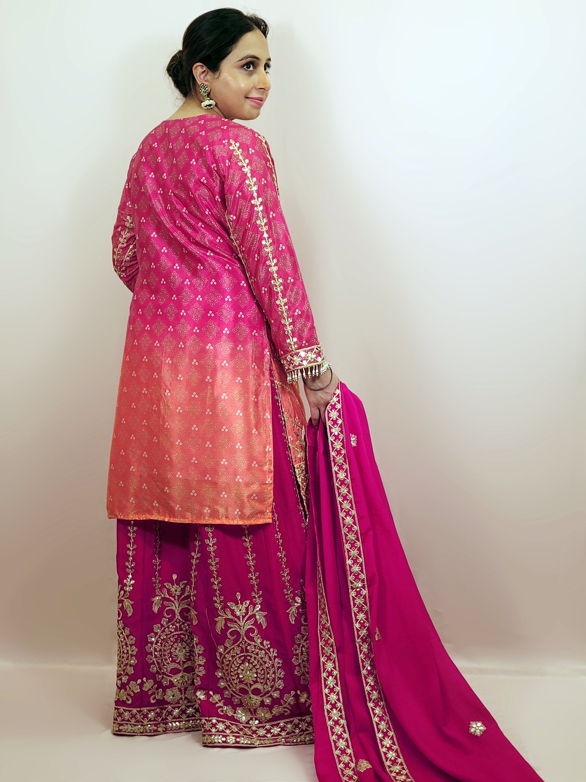 Rani Pink and Orange Shaded Kameez. Rani Sharara and Dupatta. Heavy Embroidery. Zari, Sequins and Mirror.
