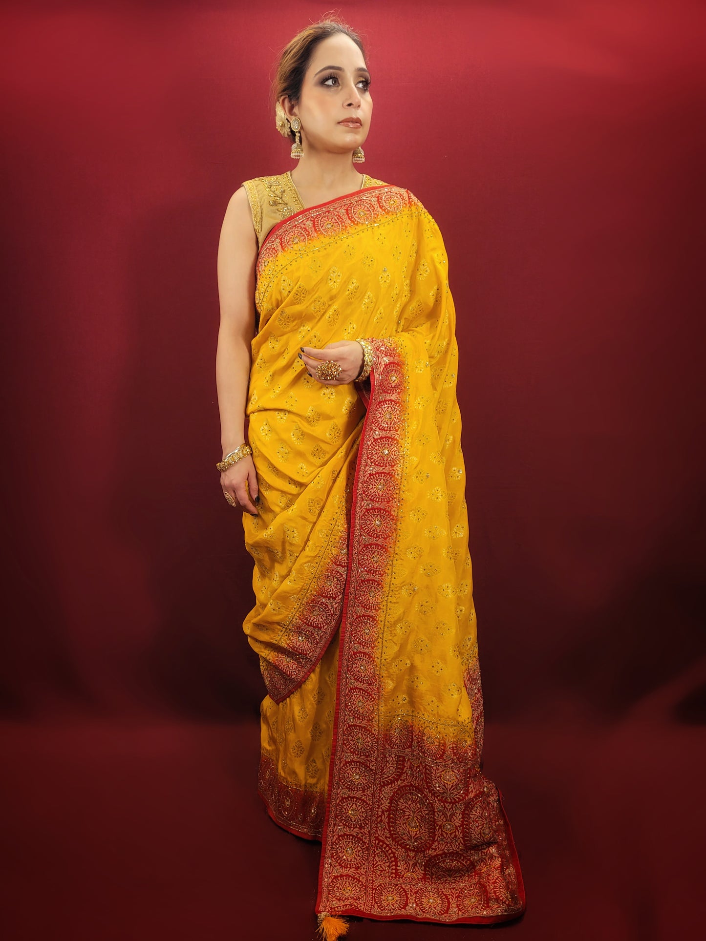 This beautiful yellow silk saree adorned with intricate zardosi and jarkan work is the perfect choice for a grand wedding celebration.