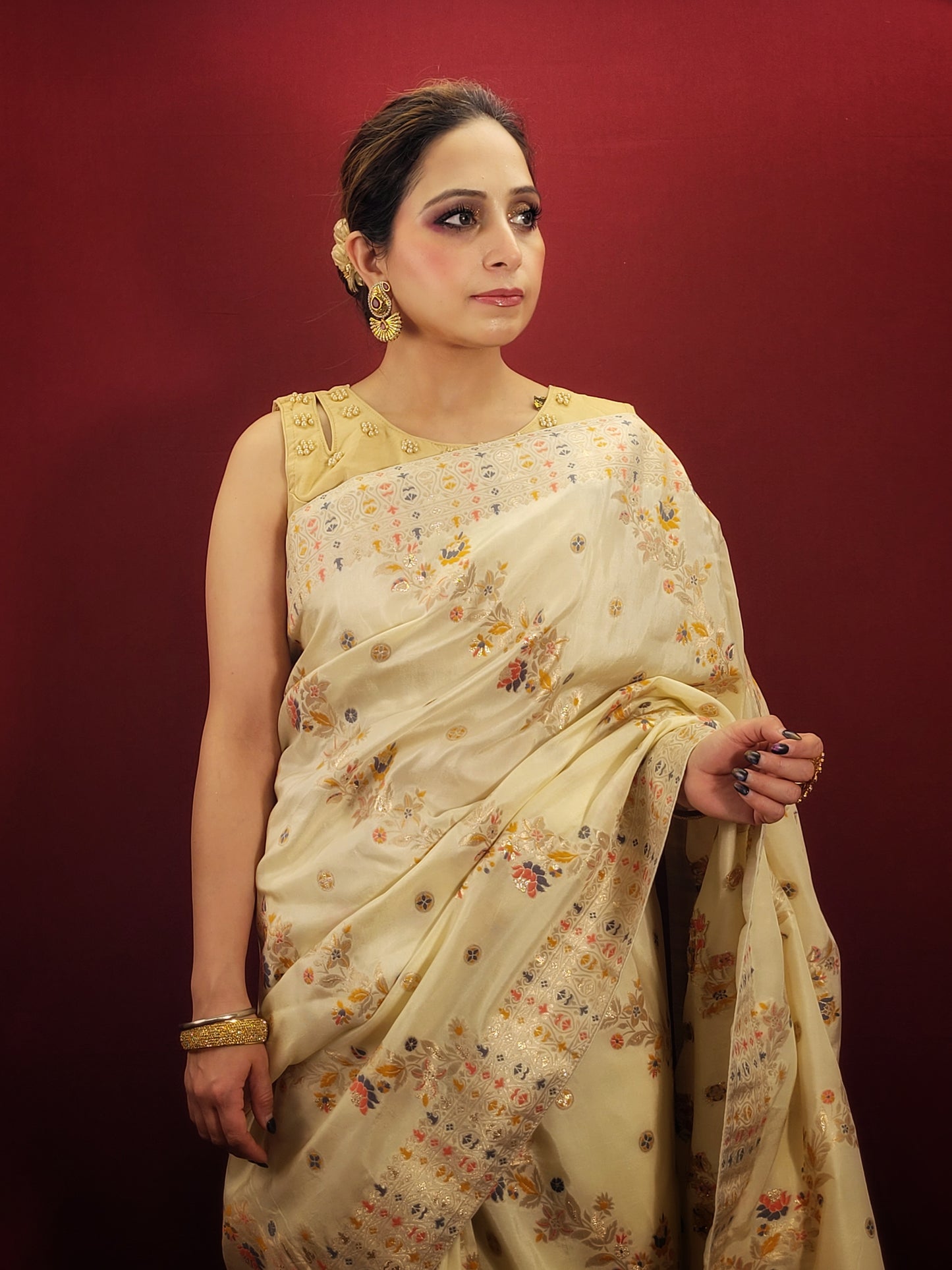Embrace the festive spirit with a creme Banarasi woven saree, crafted from the finest silk to add a touch of traditional glamour to your party wear collection.