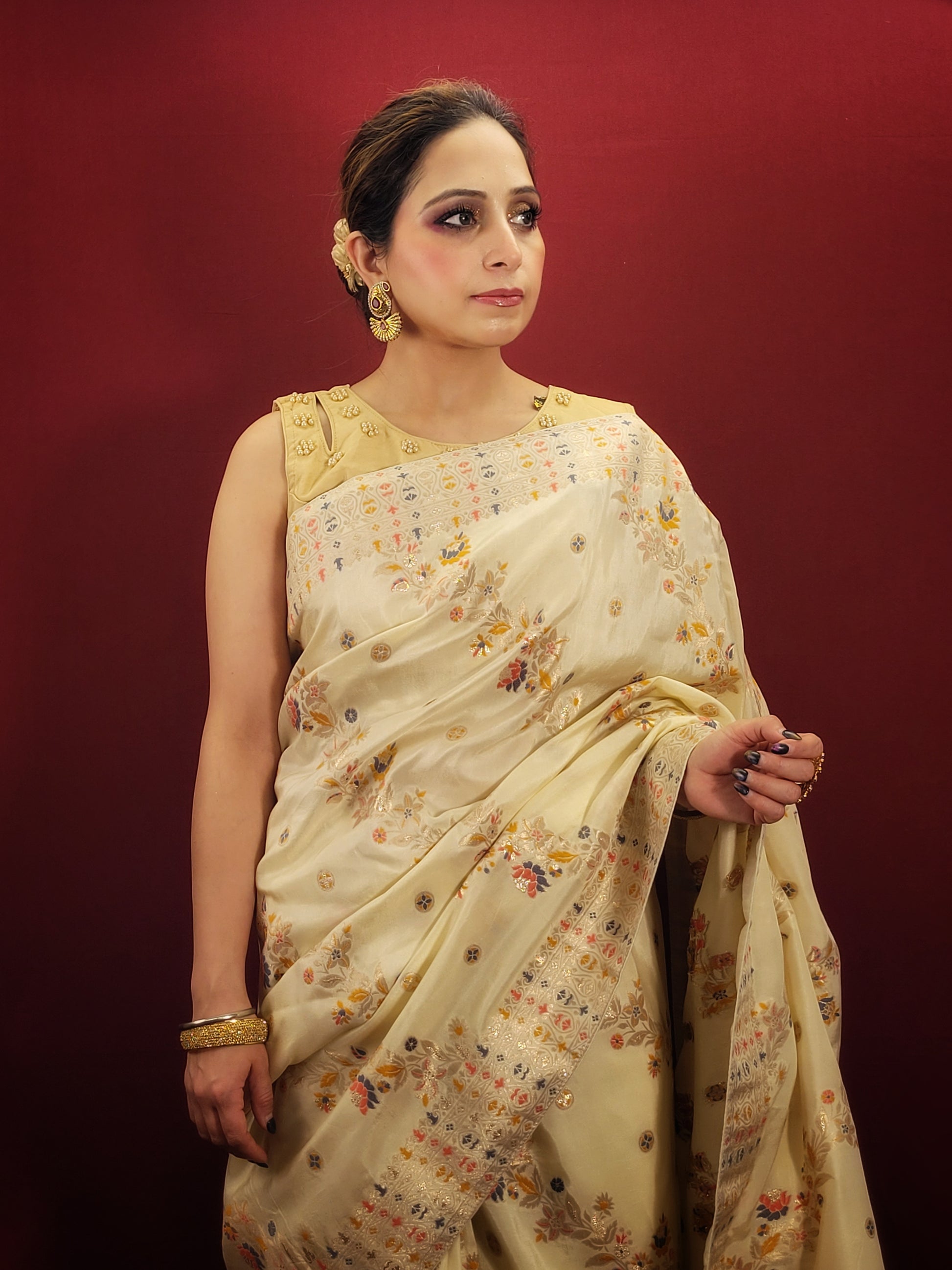 Embrace the festive spirit with a creme Banarasi woven saree, crafted from the finest silk to add a touch of traditional glamour to your party wear collection.