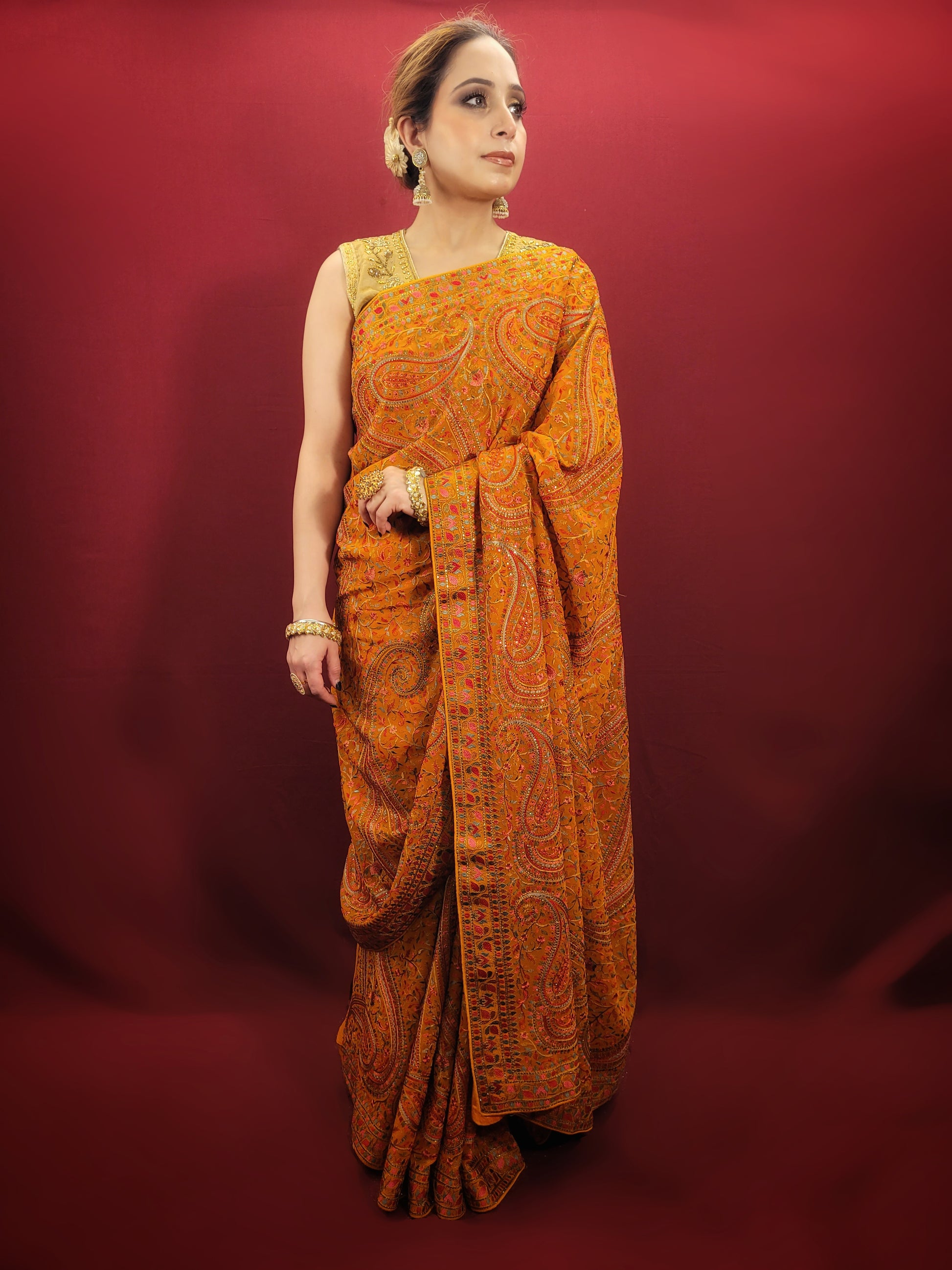 Adorn a mustard yellow georgette saree with exquisite kashmiri thread work, a versatile piece that transitions seamlessly from party wear to Puja wear.