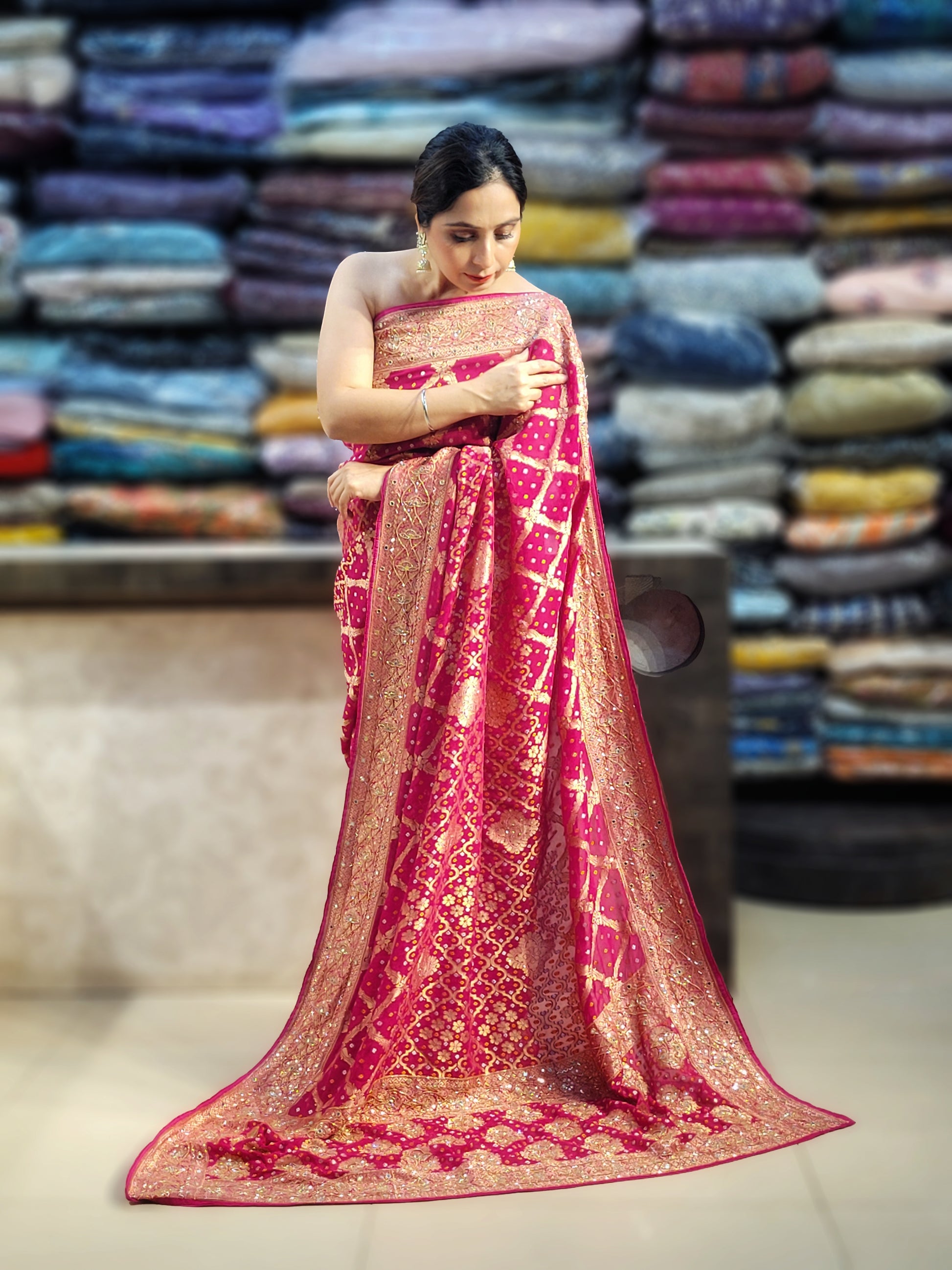 Rani Pink Georgette Banarasi (Khaddi) Bandhni Handwork Saree. Cutdana, Mirror and Sequins highlighting work. Matching unstitched blouse piece included.