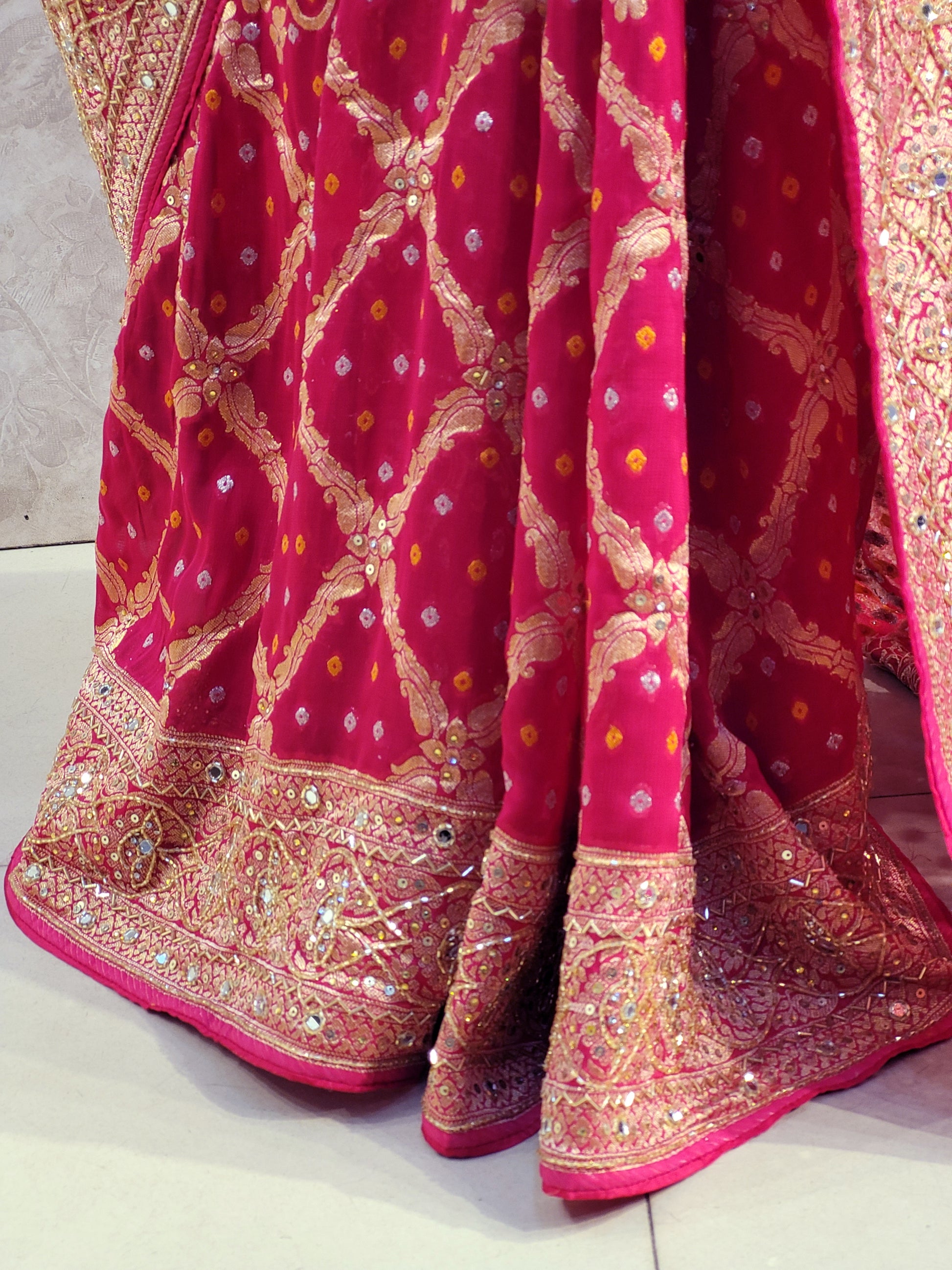 Rani Pink Georgette Banarasi (Khaddi) Bandhni Handwork Saree. Cutdana, Mirror and Sequins highlighting work. Matching unstitched blouse piece included.