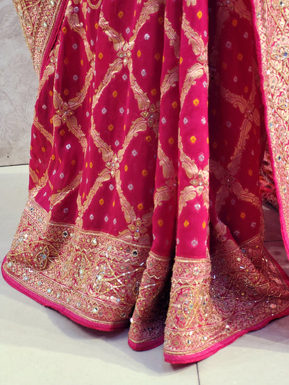 Rani Pink Georgette Banarasi (Khaddi) Bandhni Handwork Saree. Cutdana, Mirror and Sequins highlighting work. Matching unstitched blouse piece included.
