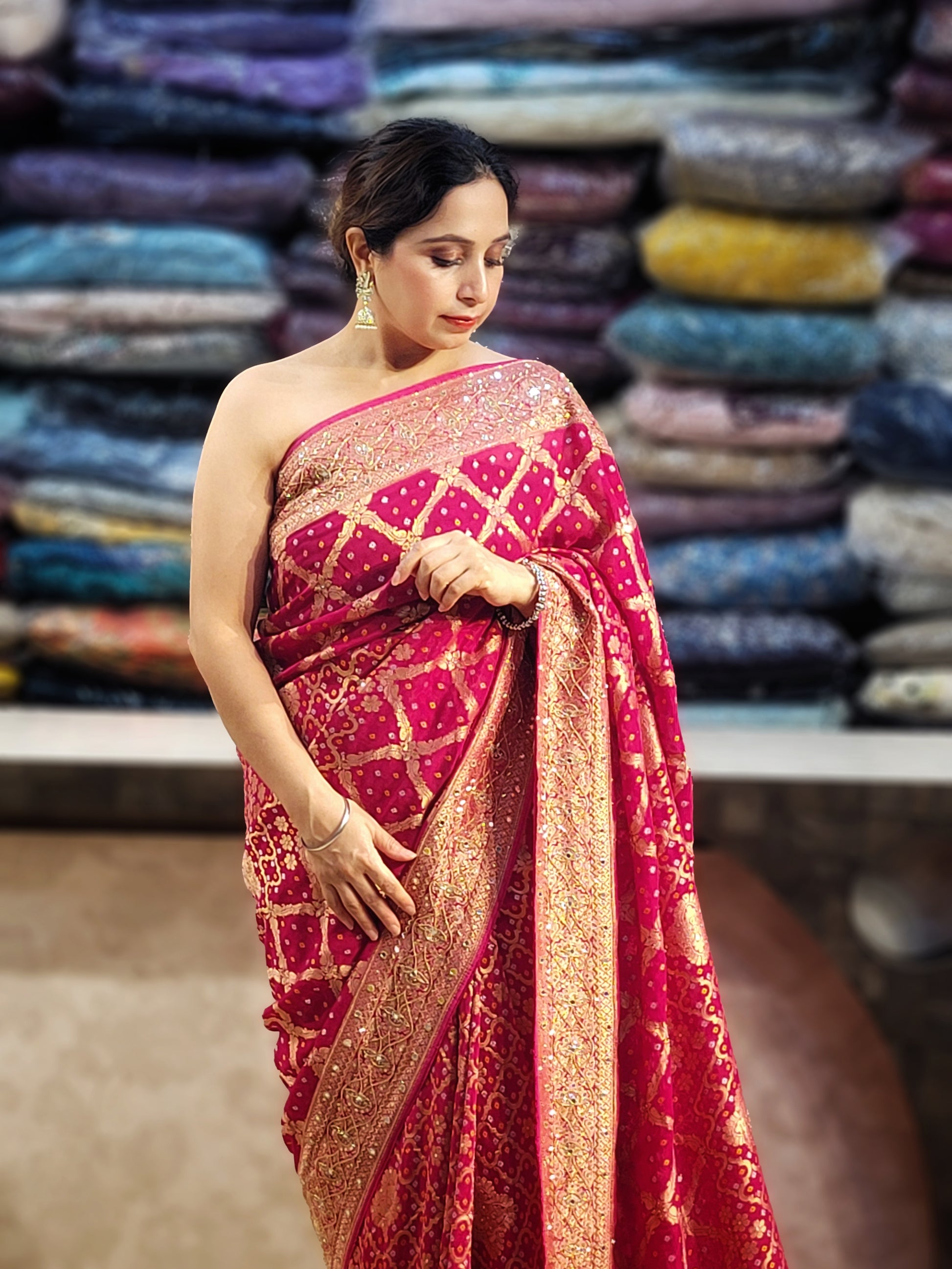 Rani Pink Georgette Banarasi (Khaddi) Bandhni Handwork Saree. Cutdana, Mirror and Sequins highlighting work. Matching unstitched blouse piece included.