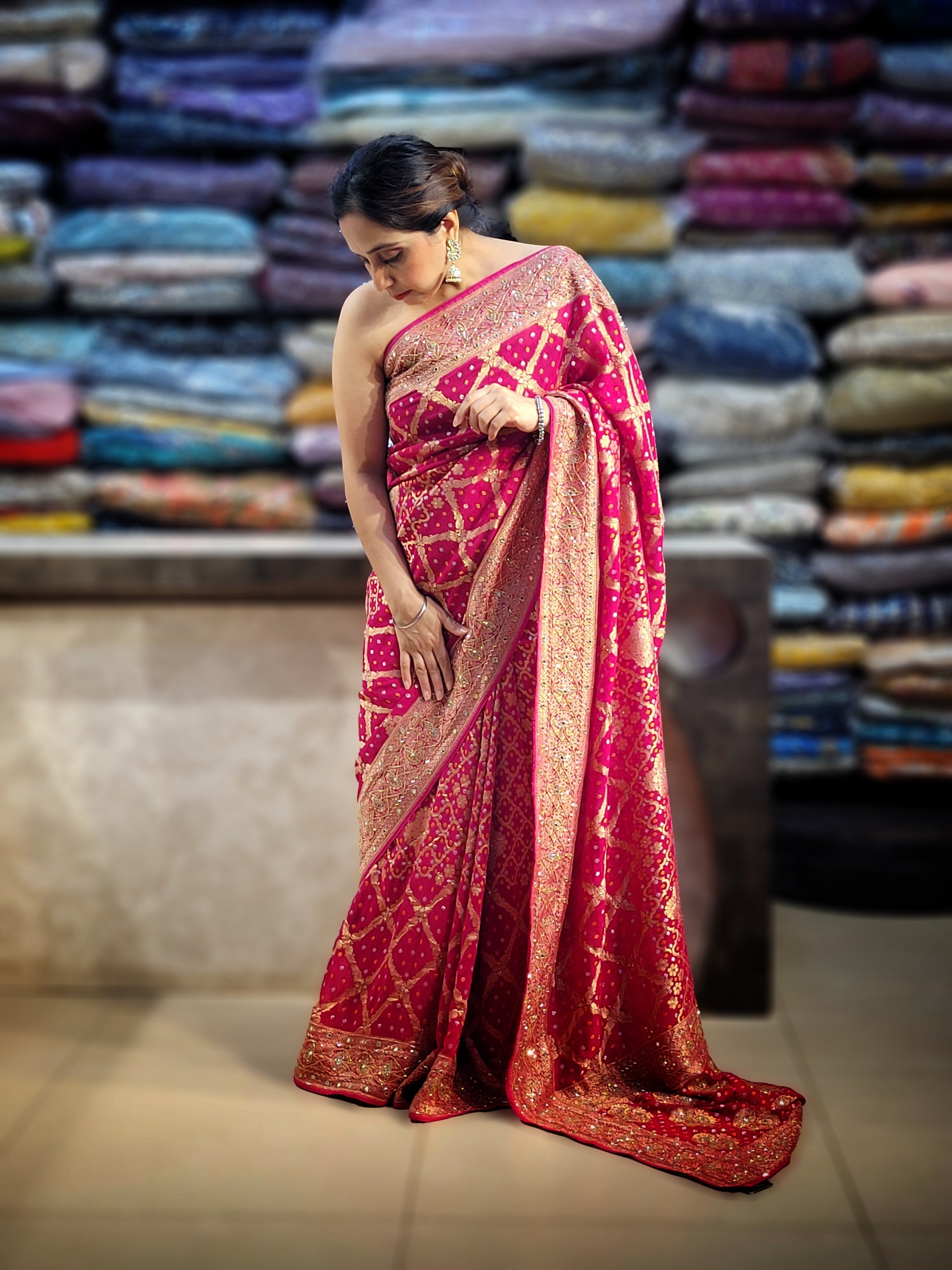 Rani Pink Georgette Banarasi (Khaddi) Bandhni Handwork Saree. Cutdana, Mirror and Sequins highlighting work. Matching unstitched blouse piece included.