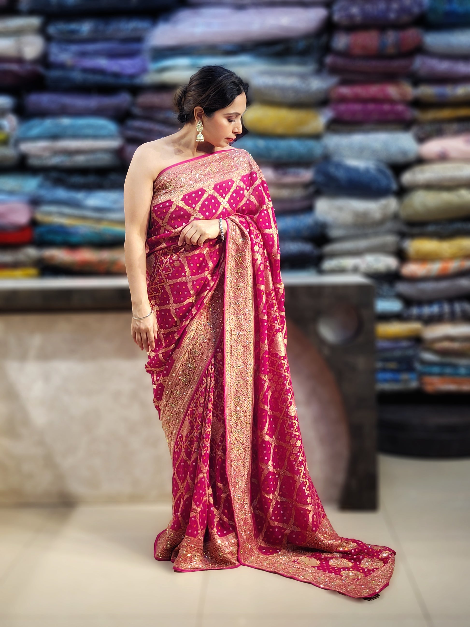 Rani Pink Georgette Banarasi (Khaddi) Bandhni Handwork Saree. Cutdana, Mirror and Sequins highlighting work. Matching unstitched blouse piece included.