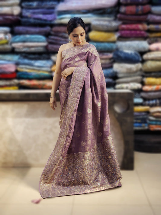 Shimmer Tissue Lavender Handwork Saree. Weaves highlighte with handworkusing Dabka, Sequins, Mirror and Resham. Unstitched Blouse Piece included.