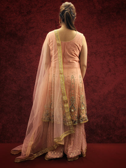 A pink indo-western ensemble featuring a net peplum top adorned with zarkan and beads, paired with a luxurious khaddi banarsi gharara, exudes a blend of contemporary flair and classic elegance.