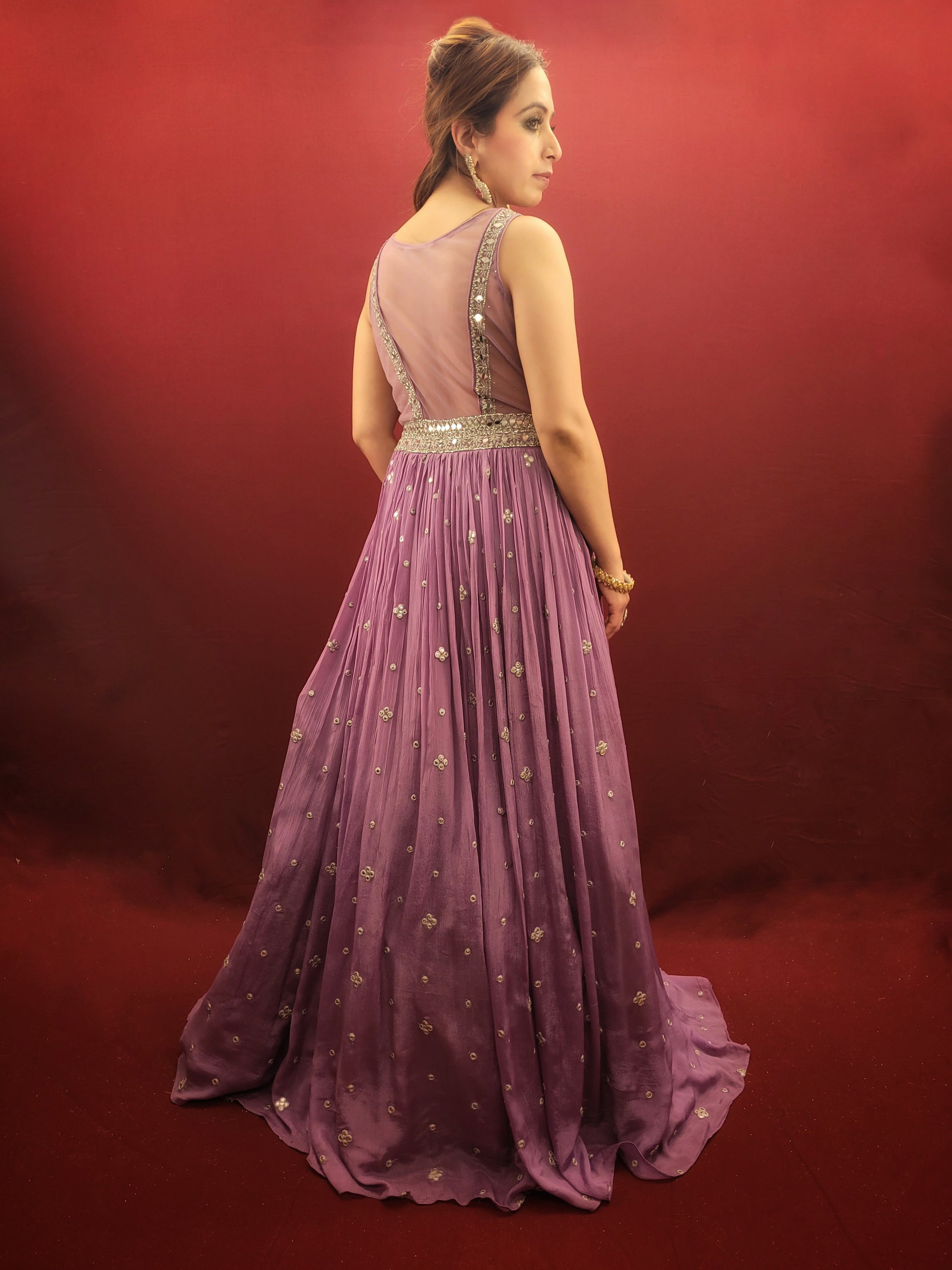 Step into the spotlight with a lavender indo-western gown, featuring dazzling mirror work on delicate chinnon fabric, an enchanting choice for engagement, party, and reception wear.