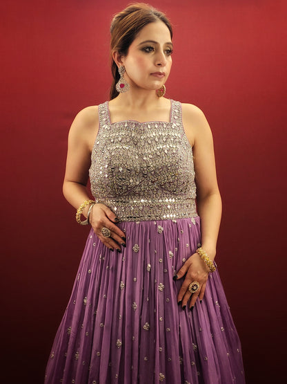 Step into the spotlight with a lavender indo-western gown, featuring dazzling mirror work on delicate chinnon fabric, an enchanting choice for engagement, party, and reception wear.