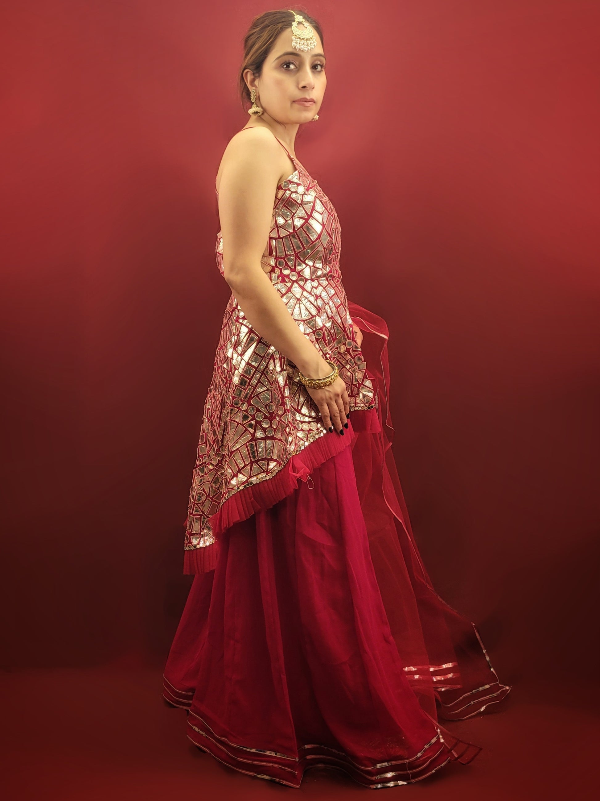 Drape yourself in a magenta indo-western Sharara adorned with intricate foil mirror work on flowy georgette, perfect for making a statement at any party wear occasion.
