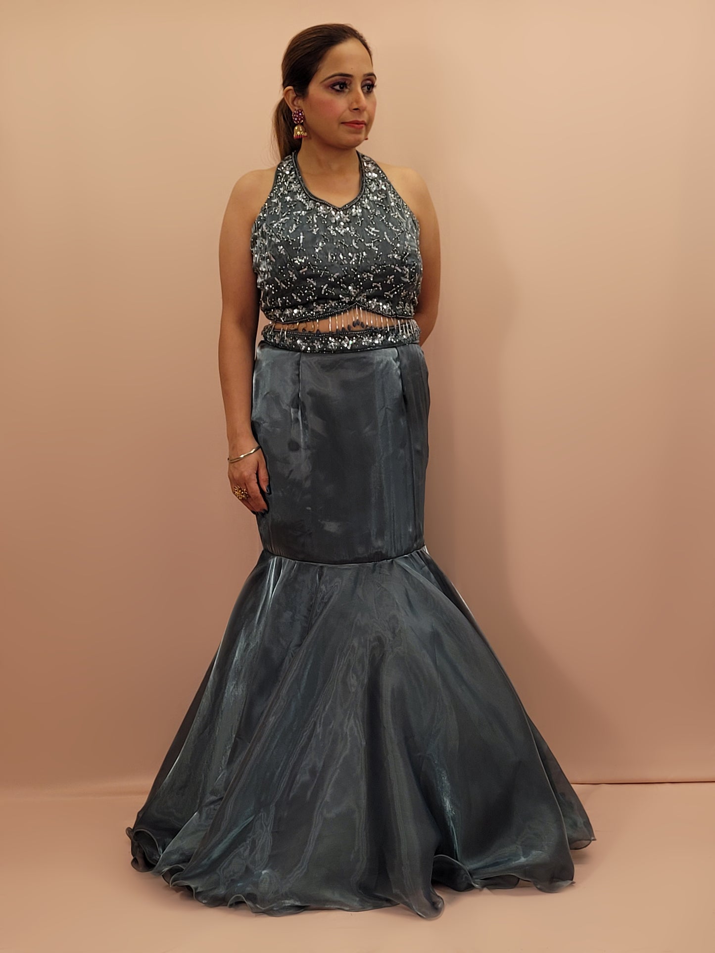 Elevate your ethnic wardrobe with this stunning Steel Blue Ready to Wear Drape Saree, crafted from luxurious Jimmy Choo fabric. This exquisite saree features a fish cut mermaid style skirt that beautifully accentuates your silhouette, flowing into a flared hem for a dramatic effect. The ensemble is completed with a hand work blouse, intricately adorned with shimmering sequins and delicate beads, adding a touch of glamour to your look.