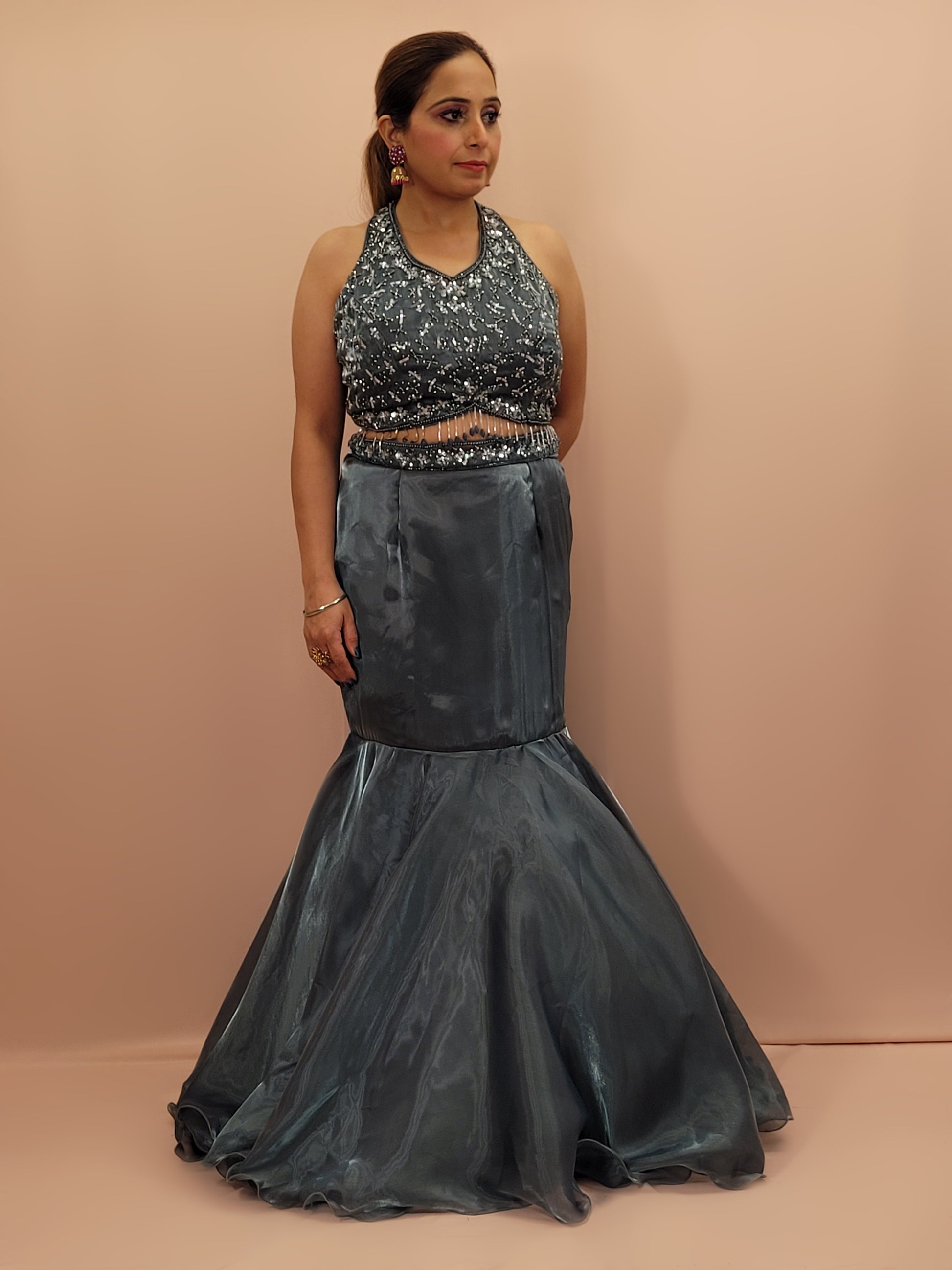 Elevate your ethnic wardrobe with this stunning Steel Blue Ready to Wear Drape Saree, crafted from luxurious Jimmy Choo fabric. This exquisite saree features a fish cut mermaid style skirt that beautifully accentuates your silhouette, flowing into a flared hem for a dramatic effect. The ensemble is completed with a hand work blouse, intricately adorned with shimmering sequins and delicate beads, adding a touch of glamour to your look.