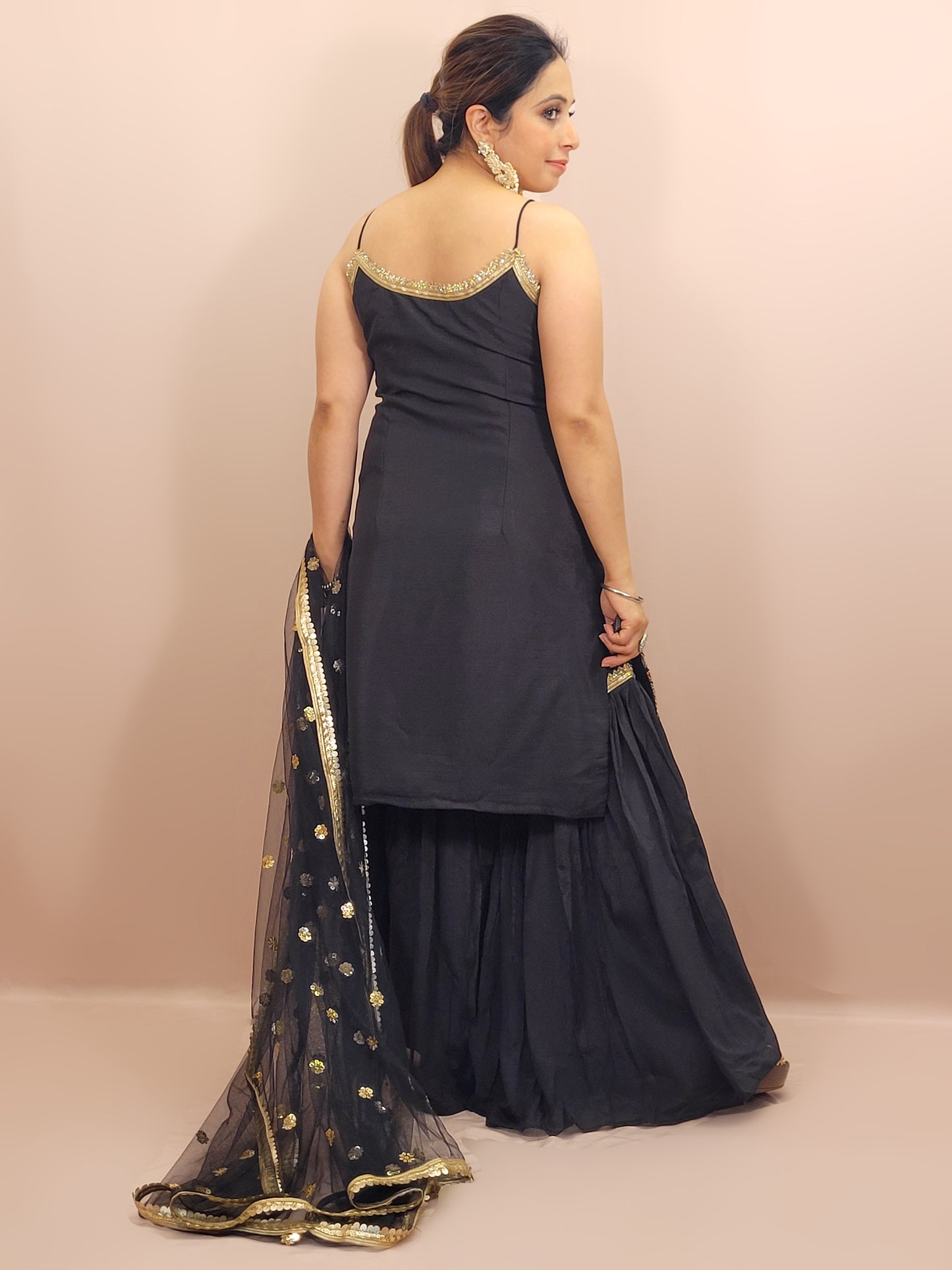 Black Sharara Suit, crafted from luxurious chinnon fabric that offers a beautiful sheen and soft drape. This ensemble is perfect for festive occasions, weddings, and celebratory events, ensuring you stand out with grace and style.