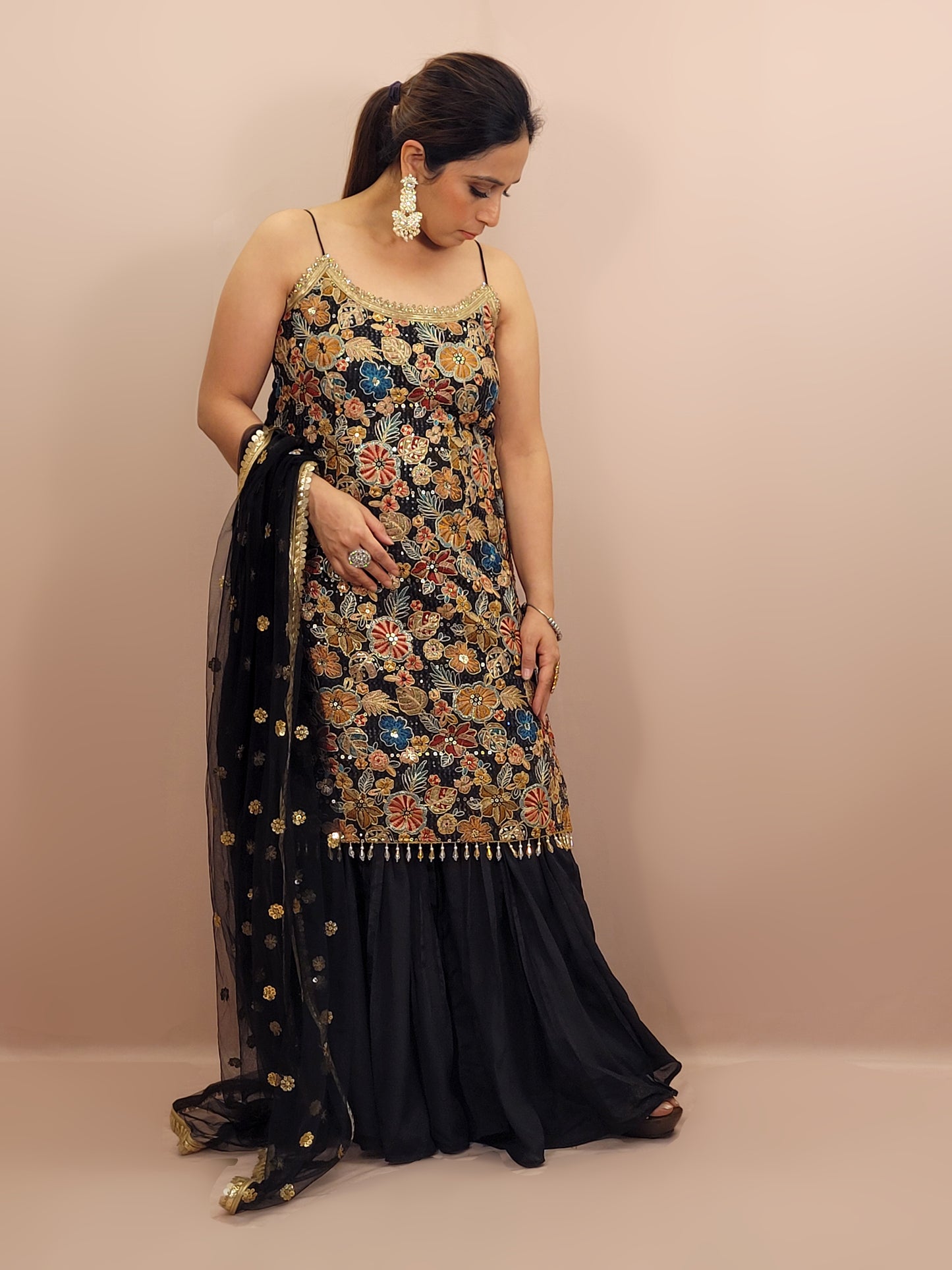 Black Sharara Suit, crafted from luxurious chinnon fabric that offers a beautiful sheen and soft drape. This ensemble is perfect for festive occasions, weddings, and celebratory events, ensuring you stand out with grace and style.
