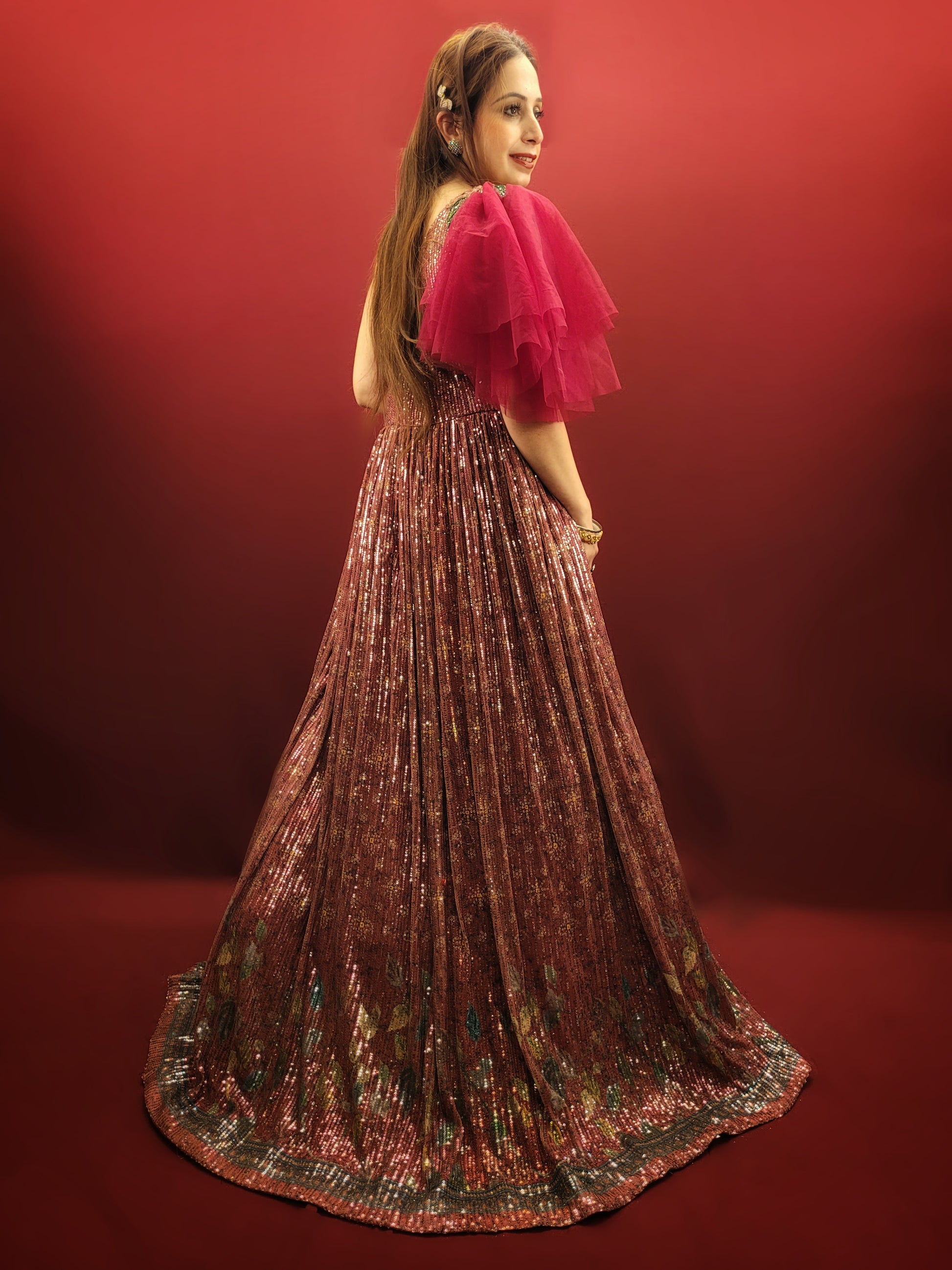 Draped in a magenta sequins gown, adorned with glass beads, crafted from the finest imported fabric, be the epitome of elegance at engagement party, truly the best-dressed bride-to-be.