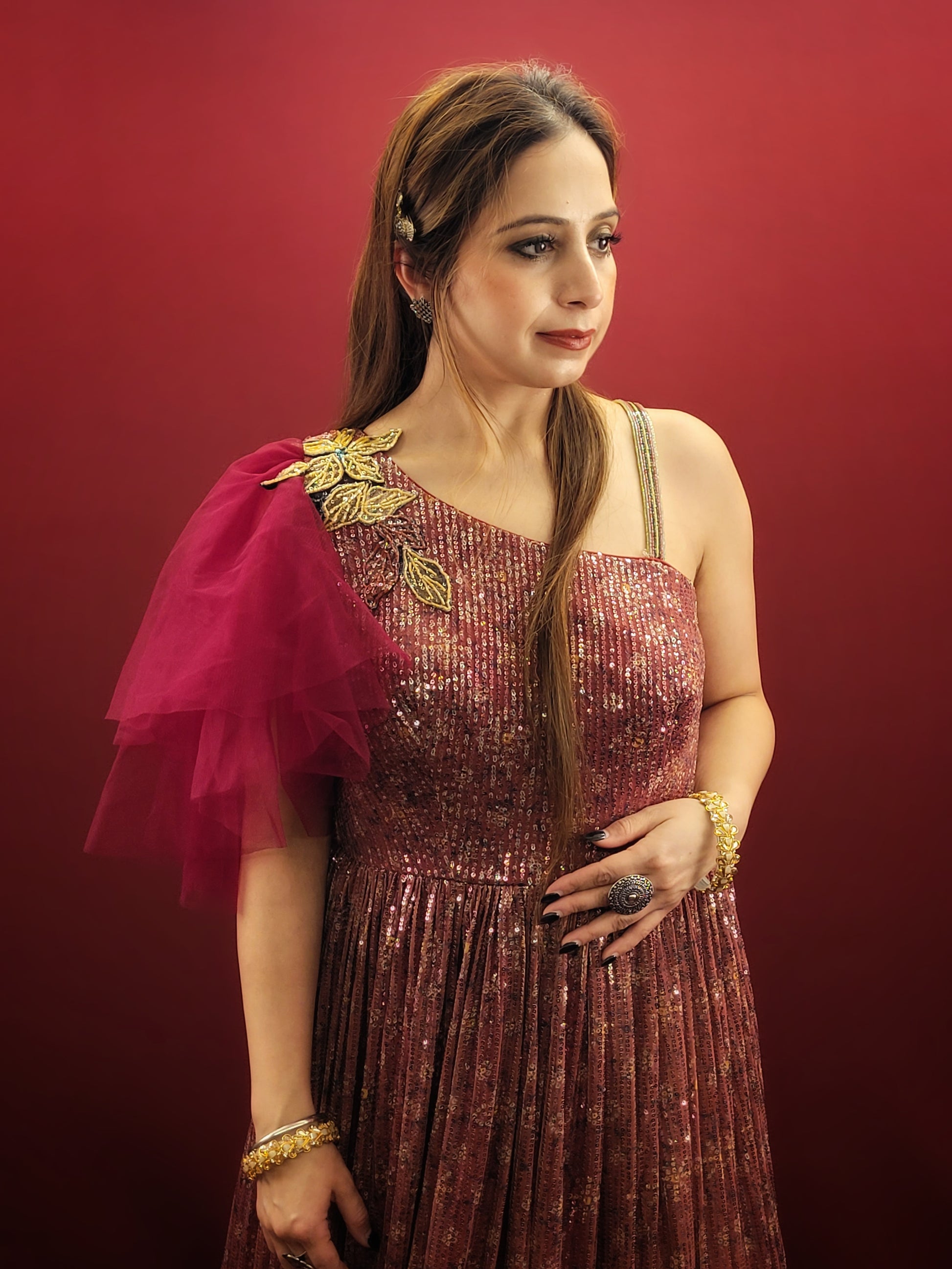 Draped in a magenta sequins gown, adorned with glass beads, crafted from the finest imported fabric, be the epitome of elegance at engagement party, truly the best-dressed bride-to-be.