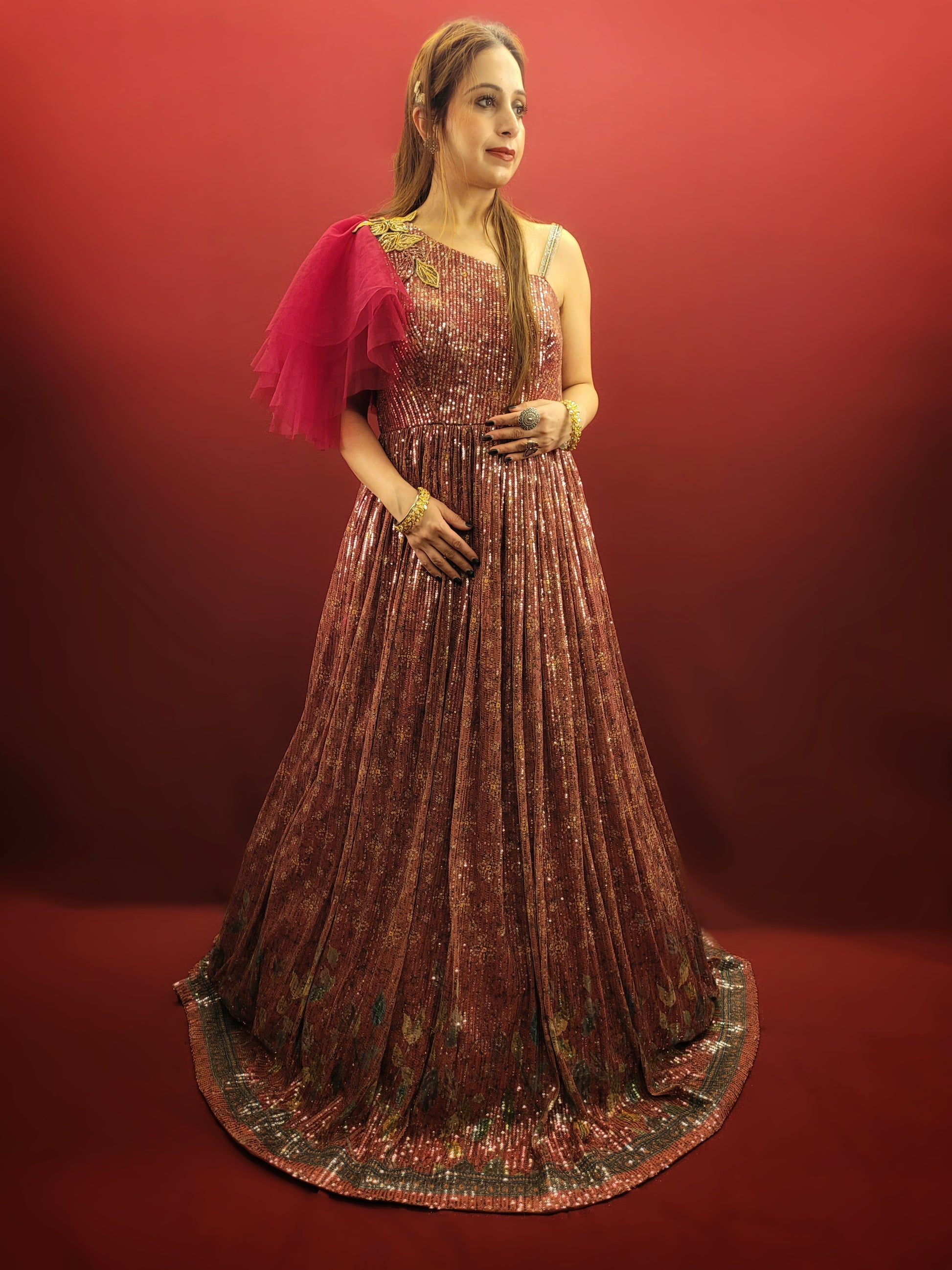 Draped in a magenta sequins gown, adorned with glass beads, crafted from the finest imported fabric, be the epitome of elegance at engagement party, truly the best-dressed bride-to-be.