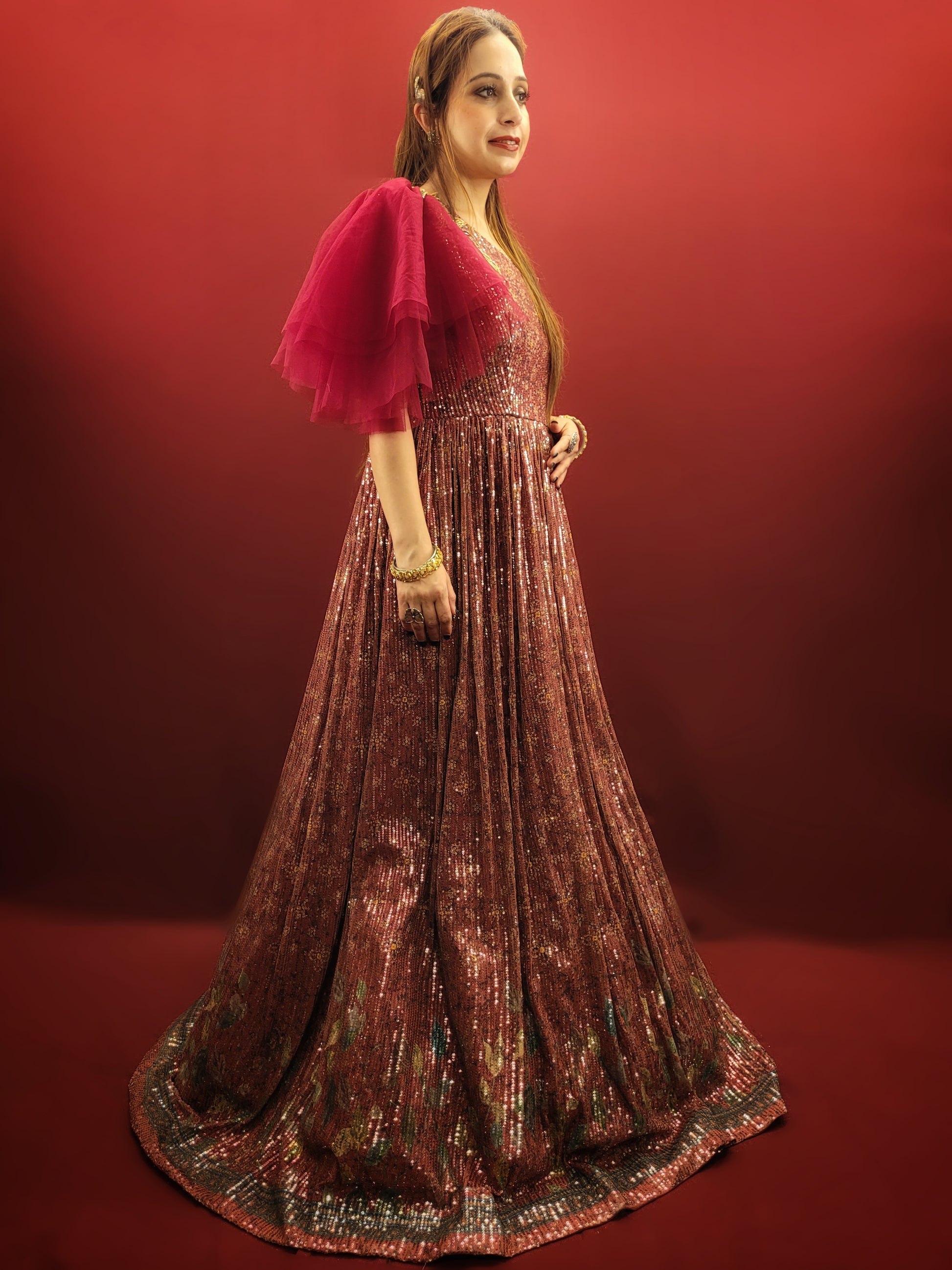 Draped in a magenta sequins gown, adorned with glass beads, crafted from the finest imported fabric, be the epitome of elegance at engagement party, truly the best-dressed bride-to-be.