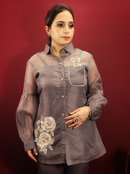 Make a statement that's both sophisticated and stylish with this stunning grey co-ord set. Perfect for a night of office revelry, kitty parties, or light celebrations, this dress will have you turning heads for all the right reasons.  Crafted from luxurious organza, the dress boasts a beautiful drape and a comfortable, lightweight feel. Exquisite resham embroidery, sparkling glass beads, and shimmering sequins add a touch of glamour that's sure to catch the light.