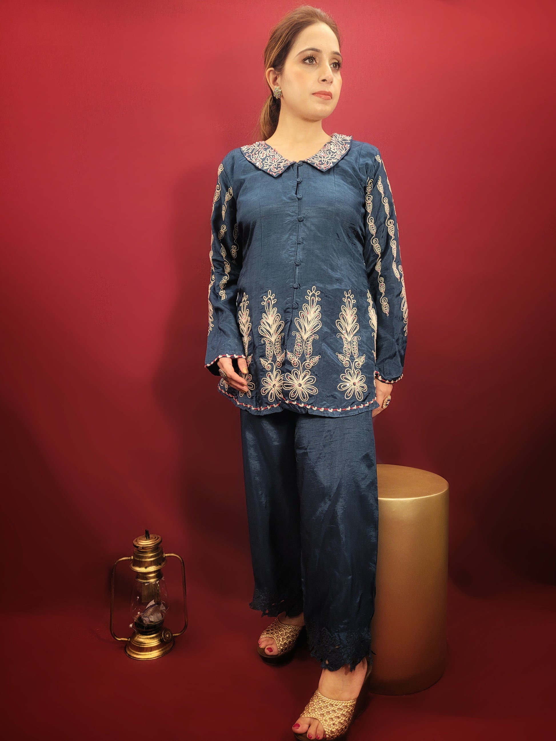 Make a statement in this stunning blue co-ord set, perfect for light parties and festive occasions. The breezy muslin fabric drapes beautifully, keeping you cool and comfortable throughout the night. The collared shirt adds a touch of sophistication, while the delicate resham and dori work with intricate cutwork on the pant mohri creates a uniquely eye-catching design.