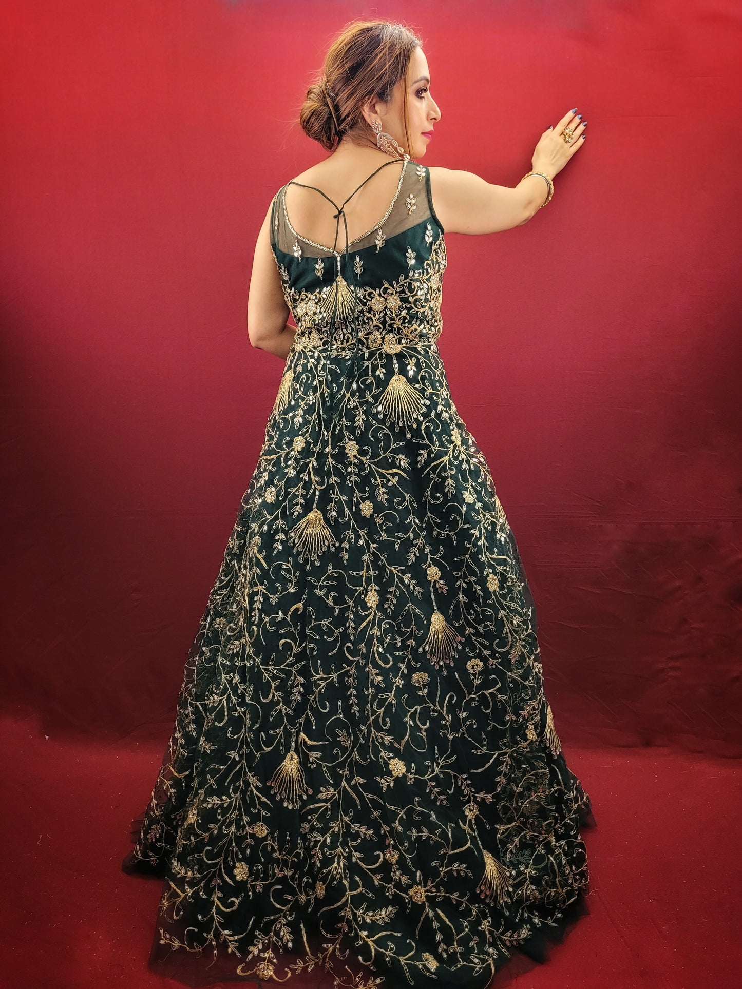 A bottle green gown, richly adorned with zari, dori & mirror work, makes for an exquisite choice for cocktail and reception ceremonies, perfectly complementing the mehendi vibrant hues.