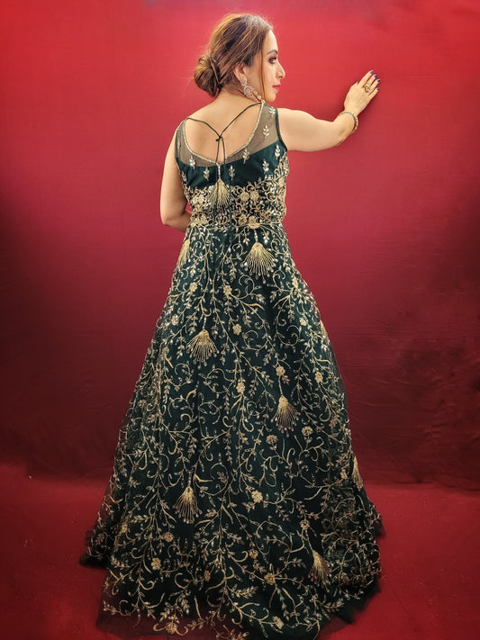 A bottle green gown, richly adorned with zari, dori & mirror work, makes for an exquisite choice for cocktail and reception ceremonies, perfectly complementing the mehendi vibrant hues.