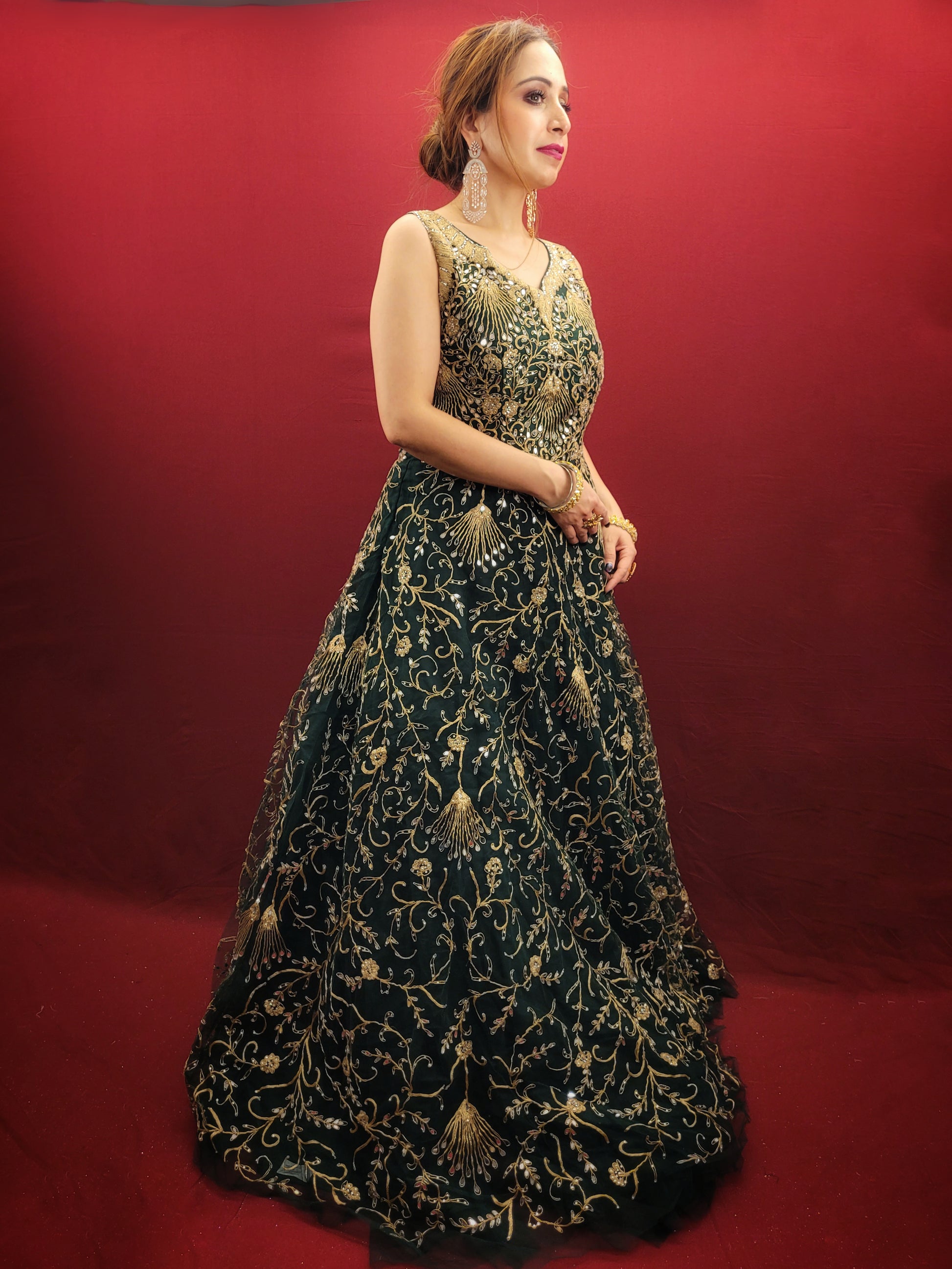 A bottle green gown, richly adorned with zari, dori & mirror work, makes for an exquisite choice for cocktail and reception ceremonies, perfectly complementing the mehendi vibrant hues.