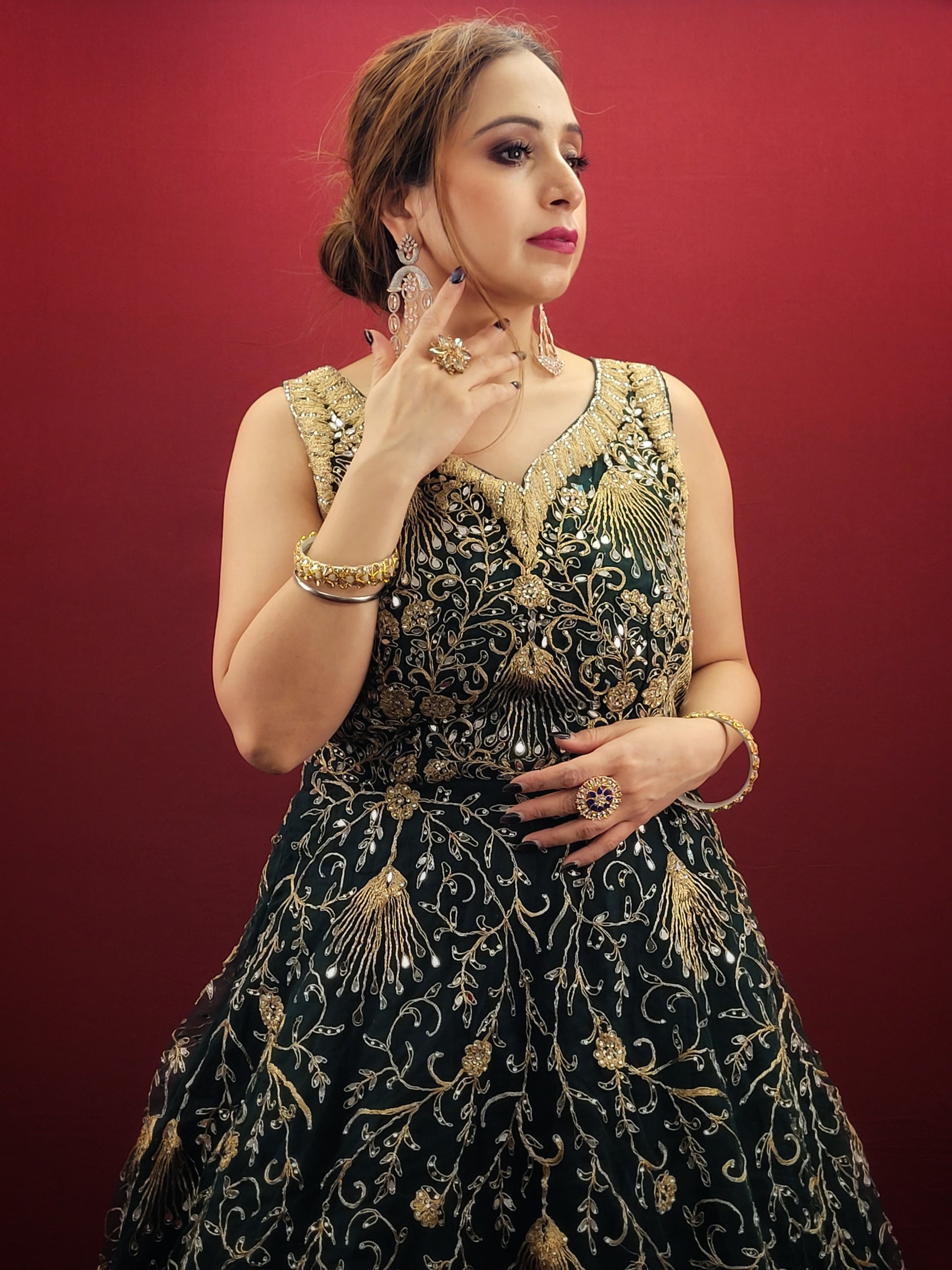 A bottle green gown, richly adorned with zari, dori & mirror work, makes for an exquisite choice for cocktail and reception ceremonies, perfectly complementing the mehendi vibrant hues.