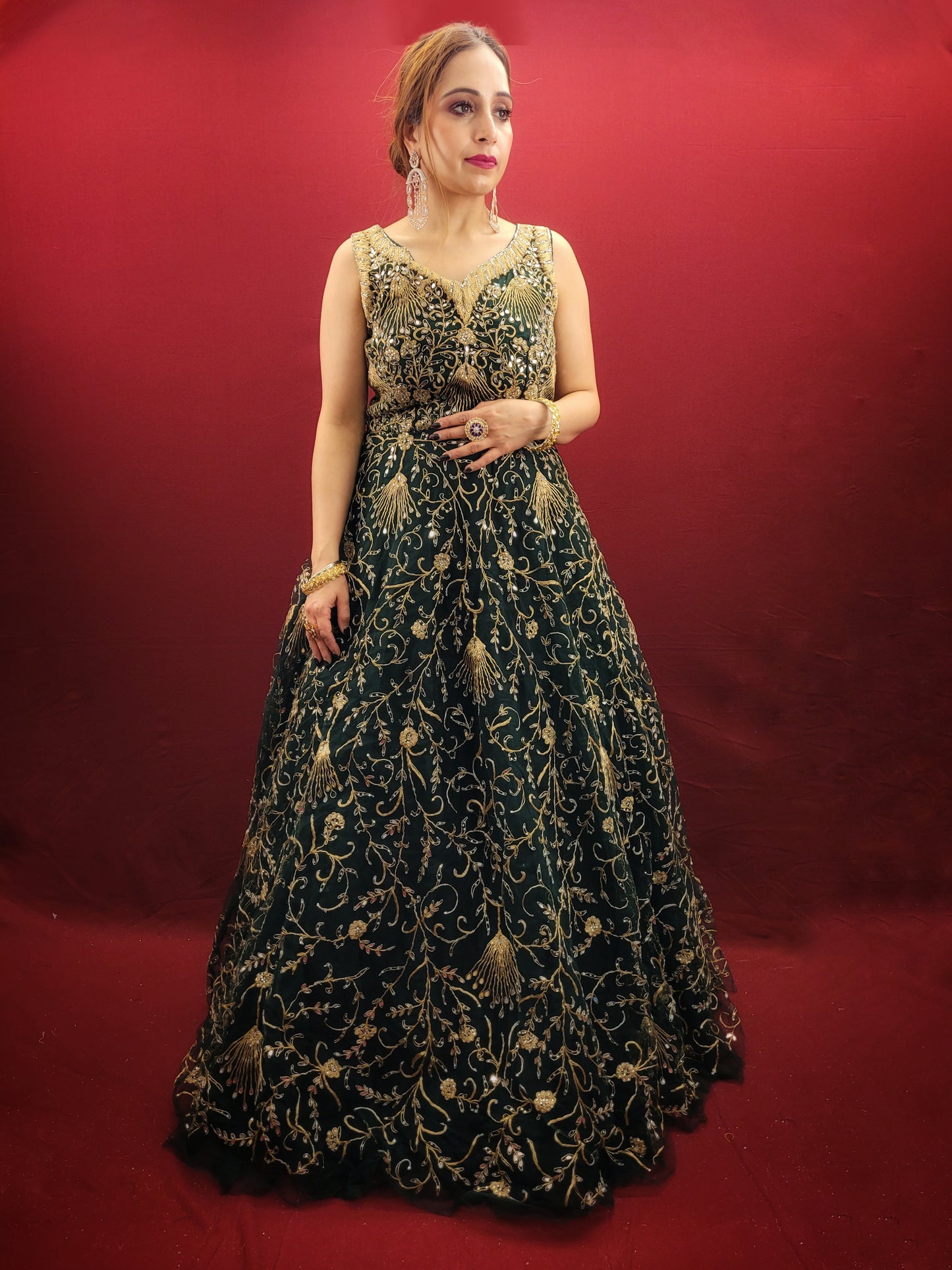 A bottle green gown, richly adorned with zari, dori & mirror work, makes for an exquisite choice for cocktail and reception ceremonies, perfectly complementing the mehendi vibrant hues.