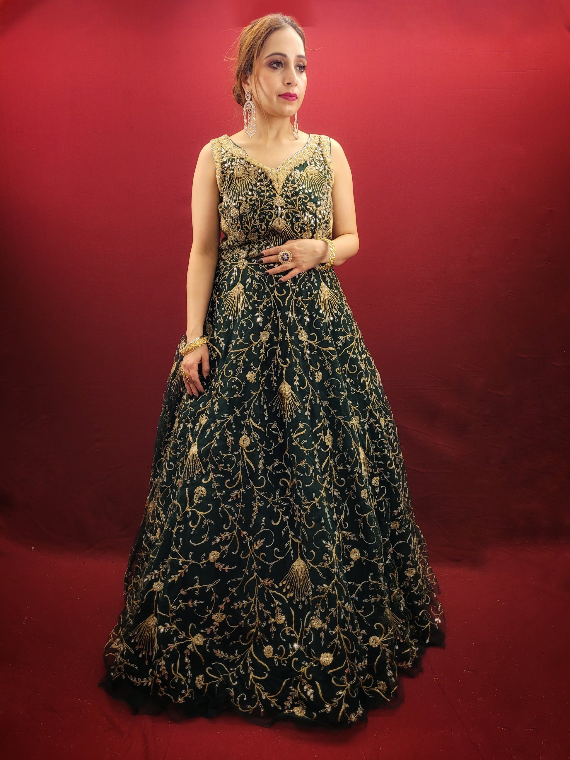 A bottle green gown, richly adorned with zari, dori & mirror work, makes for an exquisite choice for cocktail and reception ceremonies, perfectly complementing the mehendi vibrant hues.
