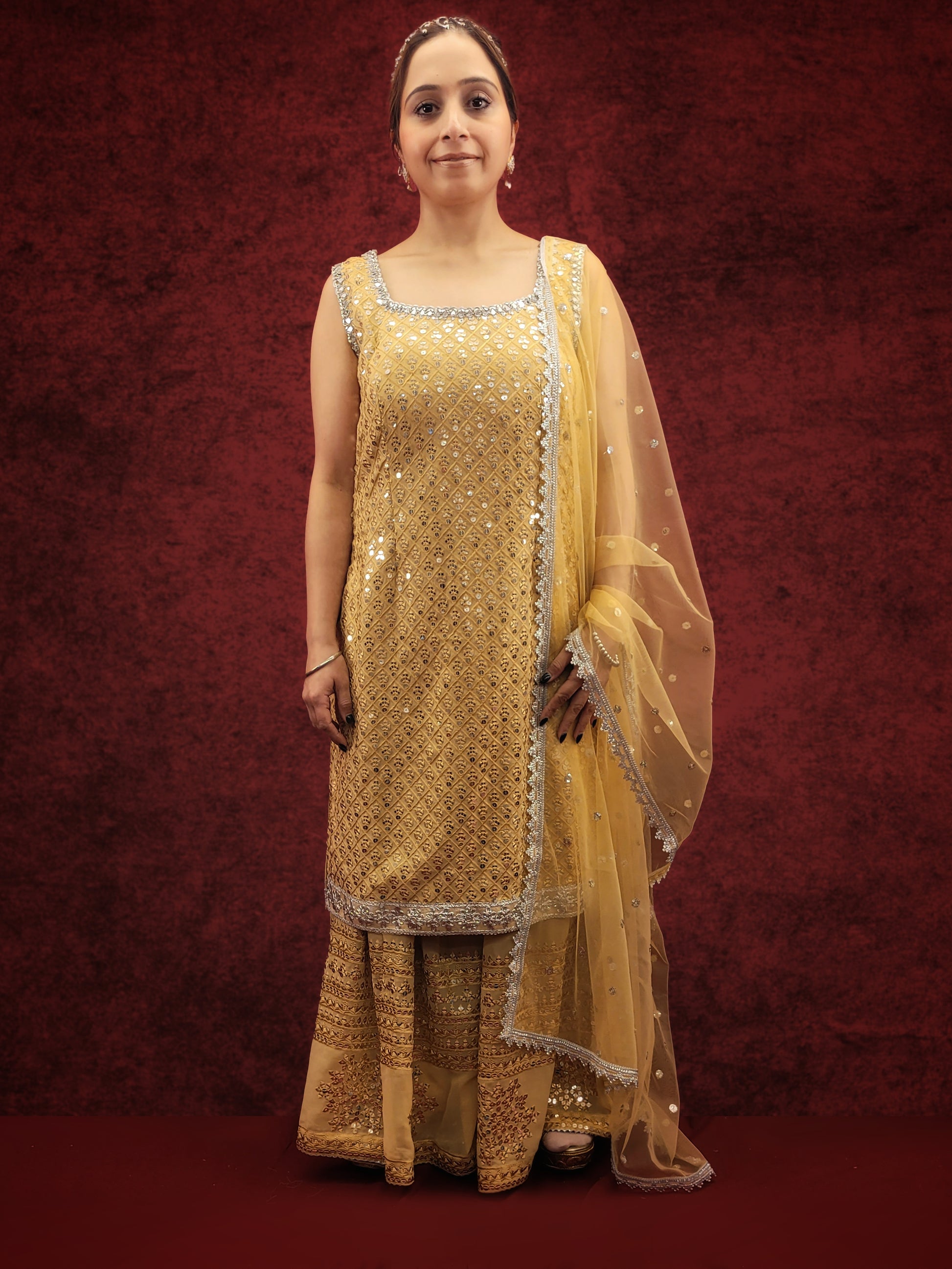 Embrace elegance with a golden beige kameez adorned with delicate sequins and thread work, paired with a gharara, for a stunning ethnic wear ensemble, ideal for party and festive occasions.