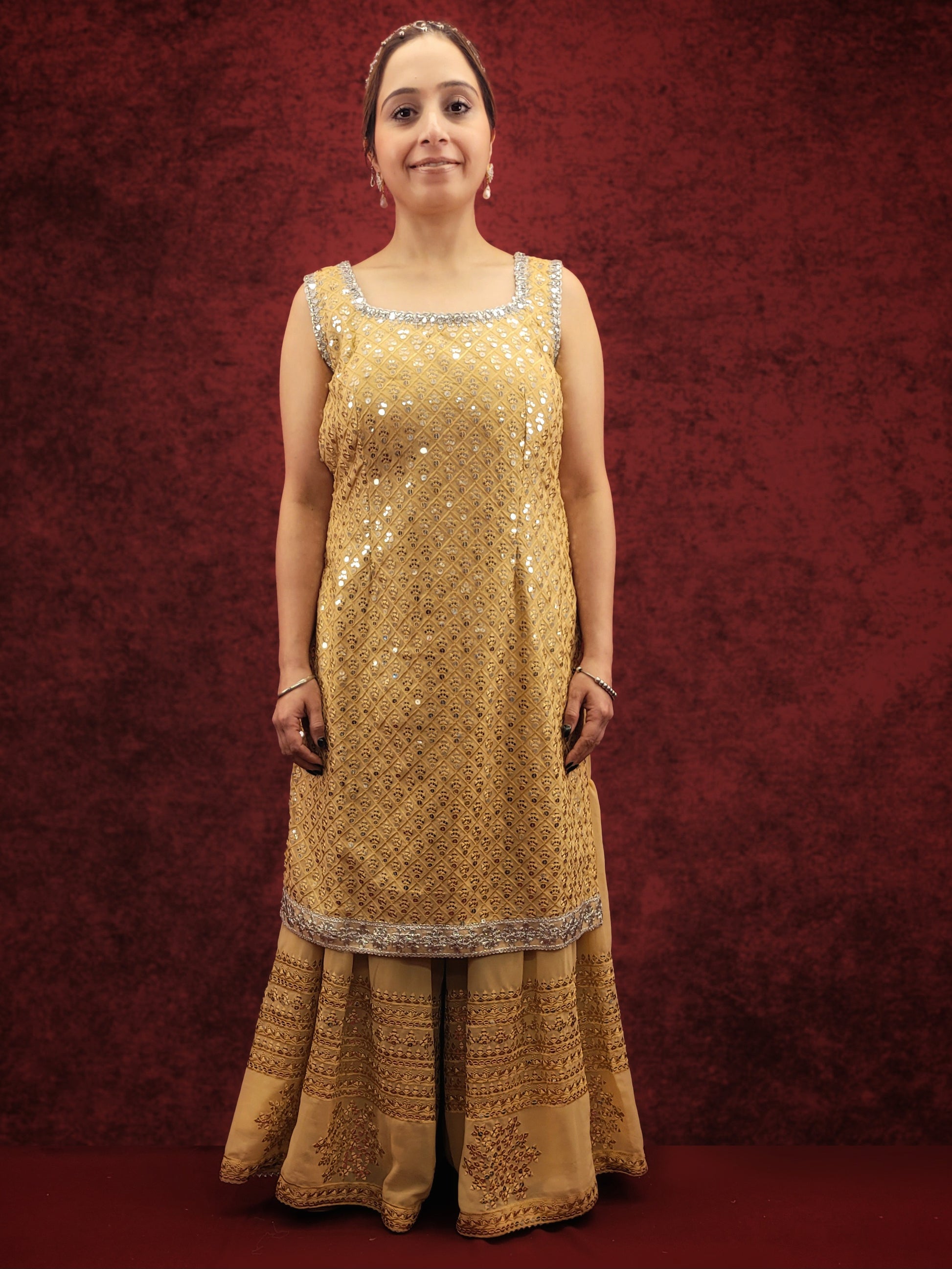 Embrace elegance with a golden beige kameez adorned with delicate sequins and thread work, paired with a gharara, for a stunning ethnic wear ensemble, ideal for party and festive occasions.
