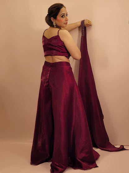 Elevate your festive wardrobe with our Maroon Shimmer Pallazo Top Indowestern Fusion Set - a perfect blend of tradition and modernity. This stunning ensemble features a sleeveless cropped blouse adorned with exquisite beadwork and sparkling sequins that catch the light beautifully. Paired with a high-waisted, flowing Pallazo in luxurious Maroon Jimmy Choo fabric, this outfit promises an elegant silhouette and timeless grace. Ideal for weddings, celebrations, or any special event