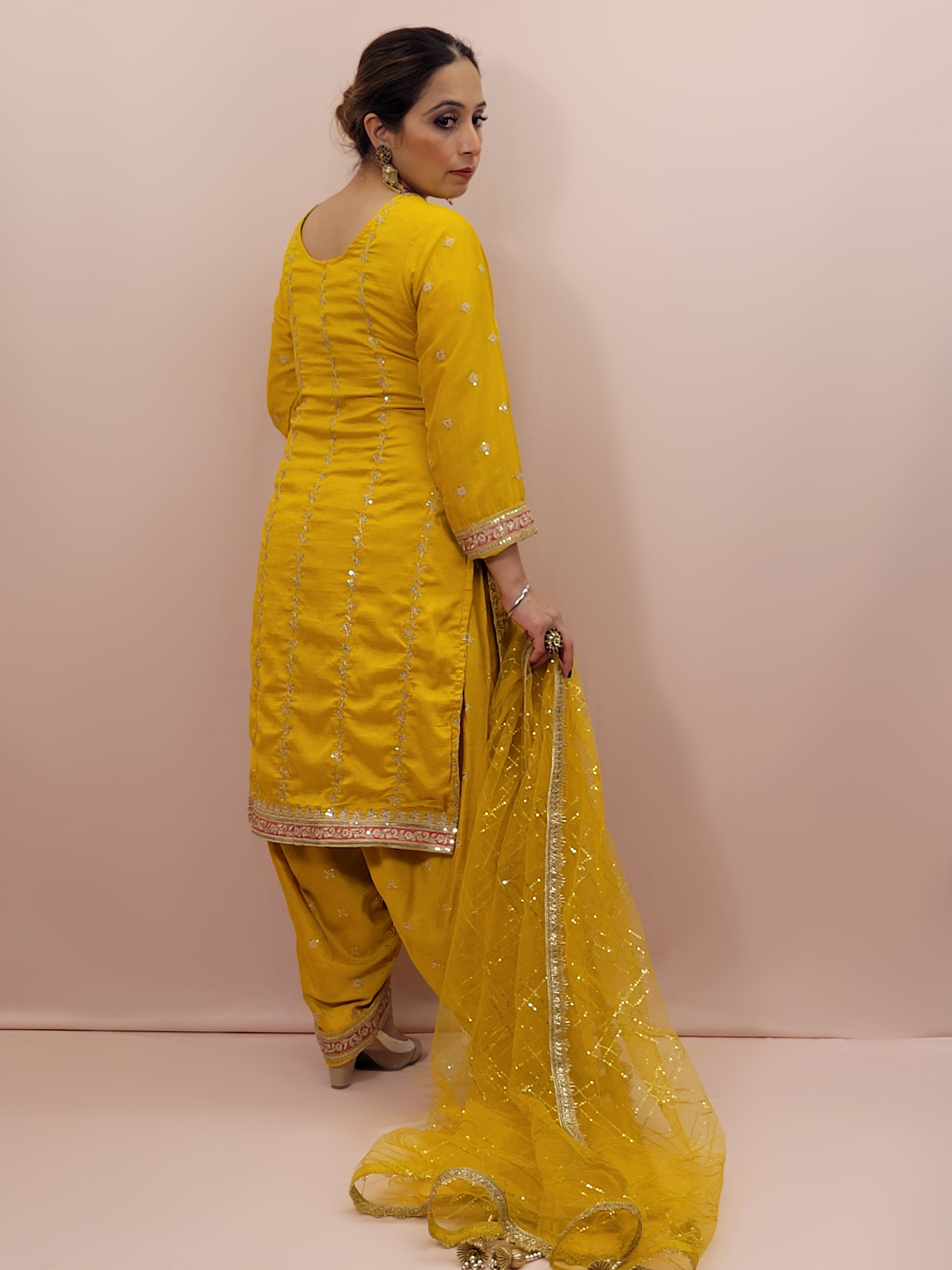 The long-sleeved kameez is paired with a simple yet sophisticated salwar, providing a balanced look that complements the ornate top. Completing the outfit is a matching yellow dupatta, embellished with similar embroidery and beadwork along its borders, adding a graceful touch to your attire.