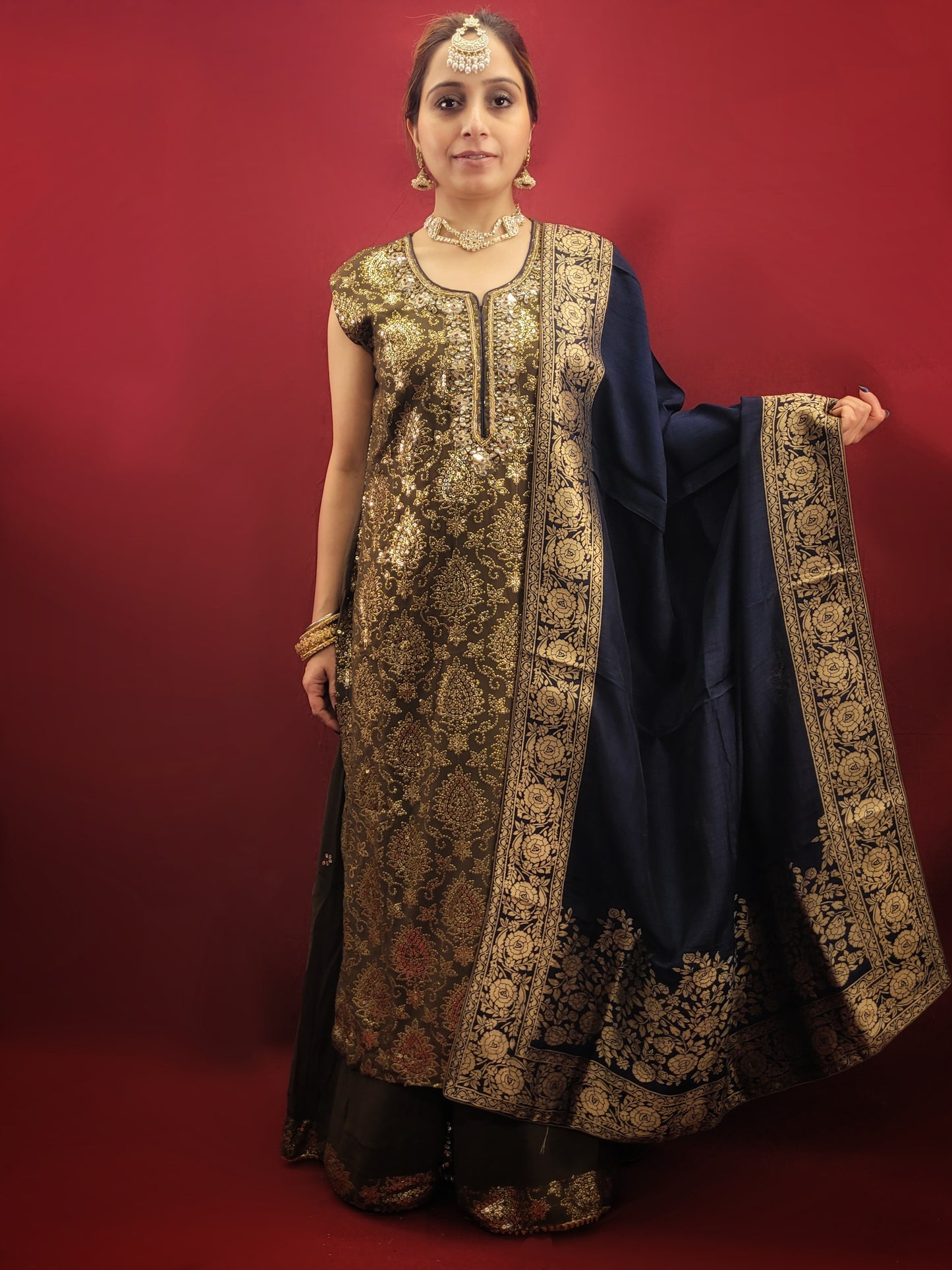 The Mehendi Green Sharara Kameez set, paired with exclusive banarasi dupatta, and adorned with sequins, kundan and beads, is a georgette masterpiece for wedding and party ethnic wear.
