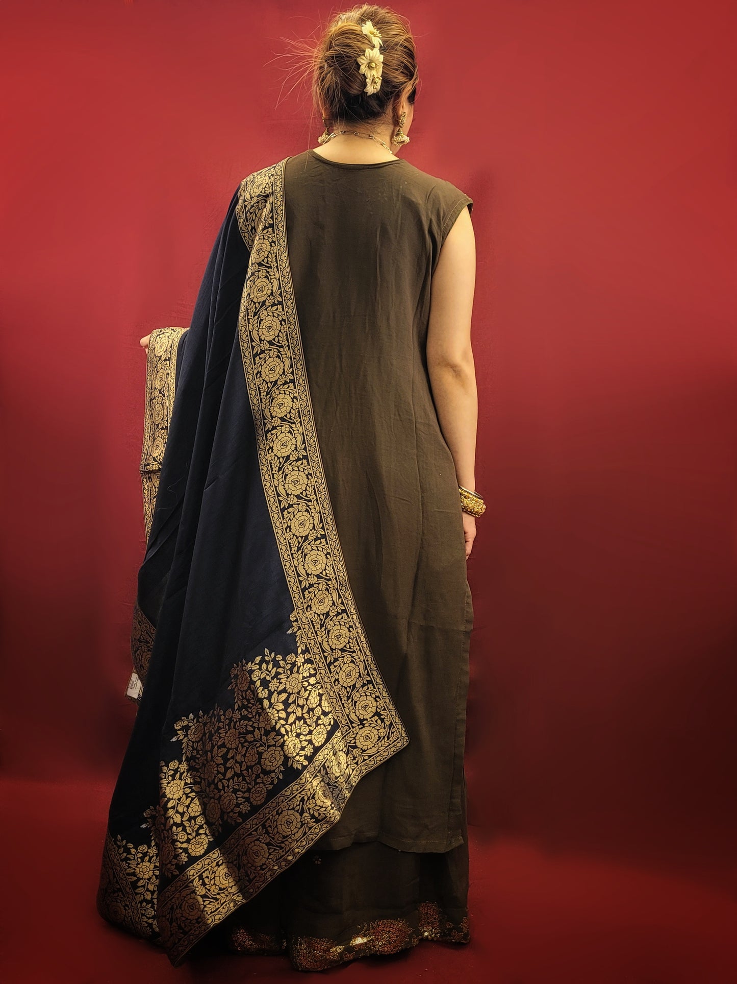 The Mehendi Green Sharara Kameez set, paired with exclusive banarasi dupatta, and adorned with sequins, kundan and beads, is a georgette masterpiece for wedding and party ethnic wear.