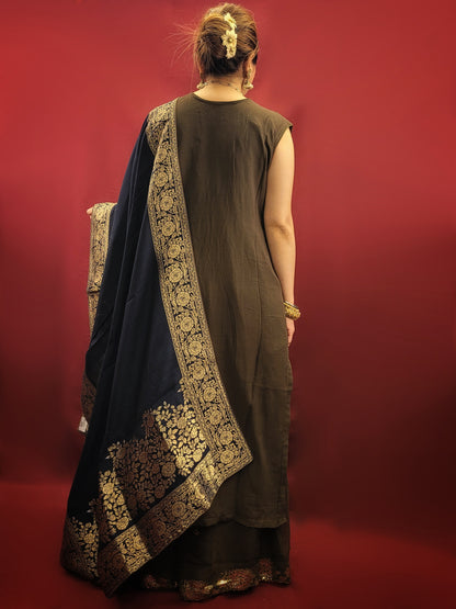 The Mehendi Green Sharara Kameez set, paired with exclusive banarasi dupatta, and adorned with sequins, kundan and beads, is a georgette masterpiece for wedding and party ethnic wear.